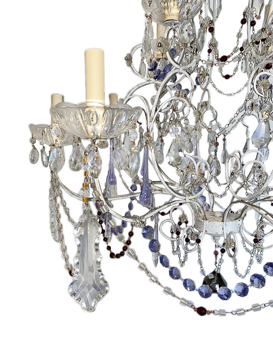 A French circa 1920s twelve-arm crystal double-tiered chandelier with white body and amethyst and smoke colored crystals.

Measurements:
Height of body 36.5
