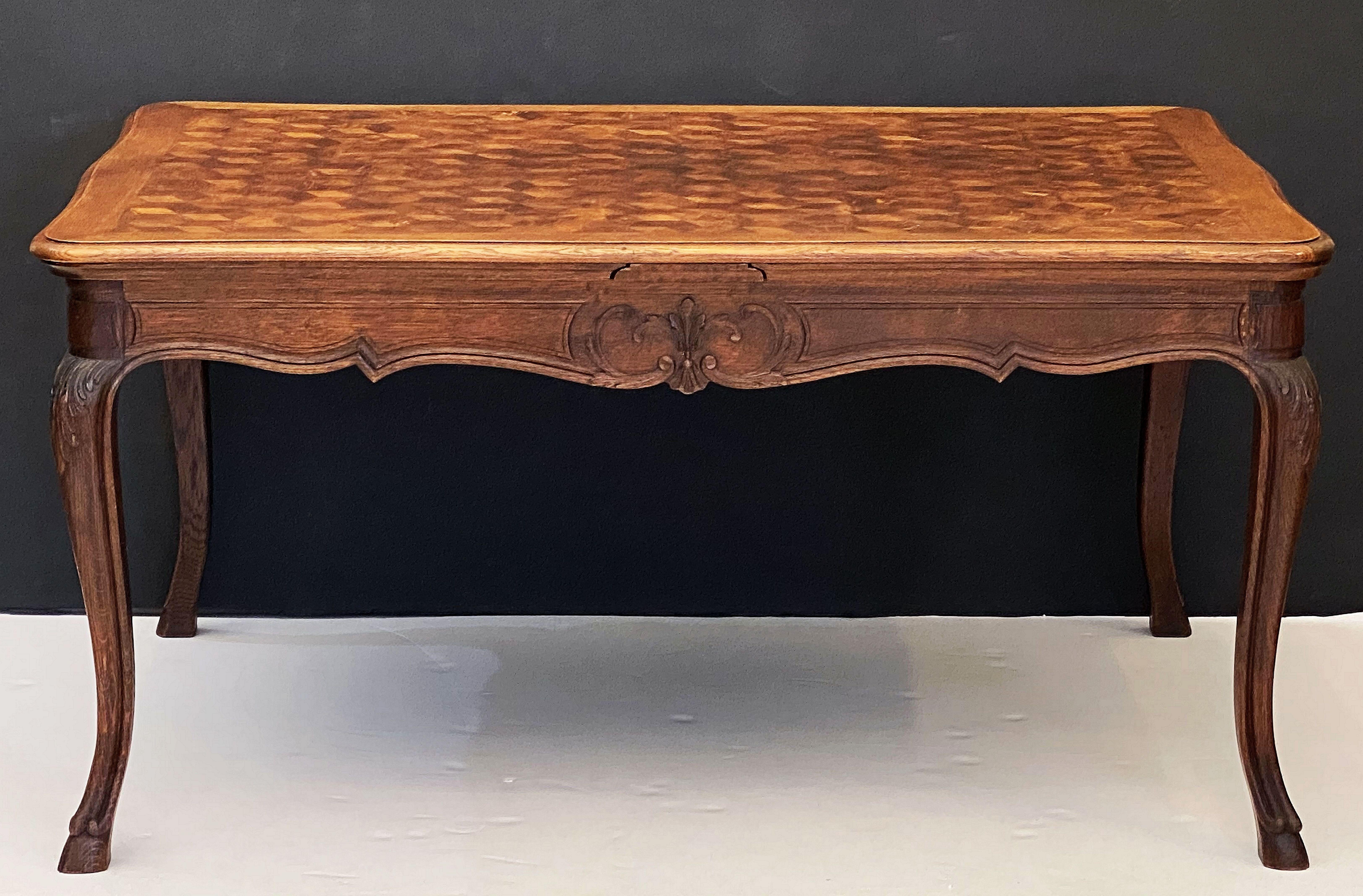 A French draw-leaf dining or breakfast table of oak, featuring a handsome rectangular top with a stylish parquetry design on a frame with decorative carved relief, two opposing pull-out draw leaves, and resting on four cabriole legs.

Dimensions