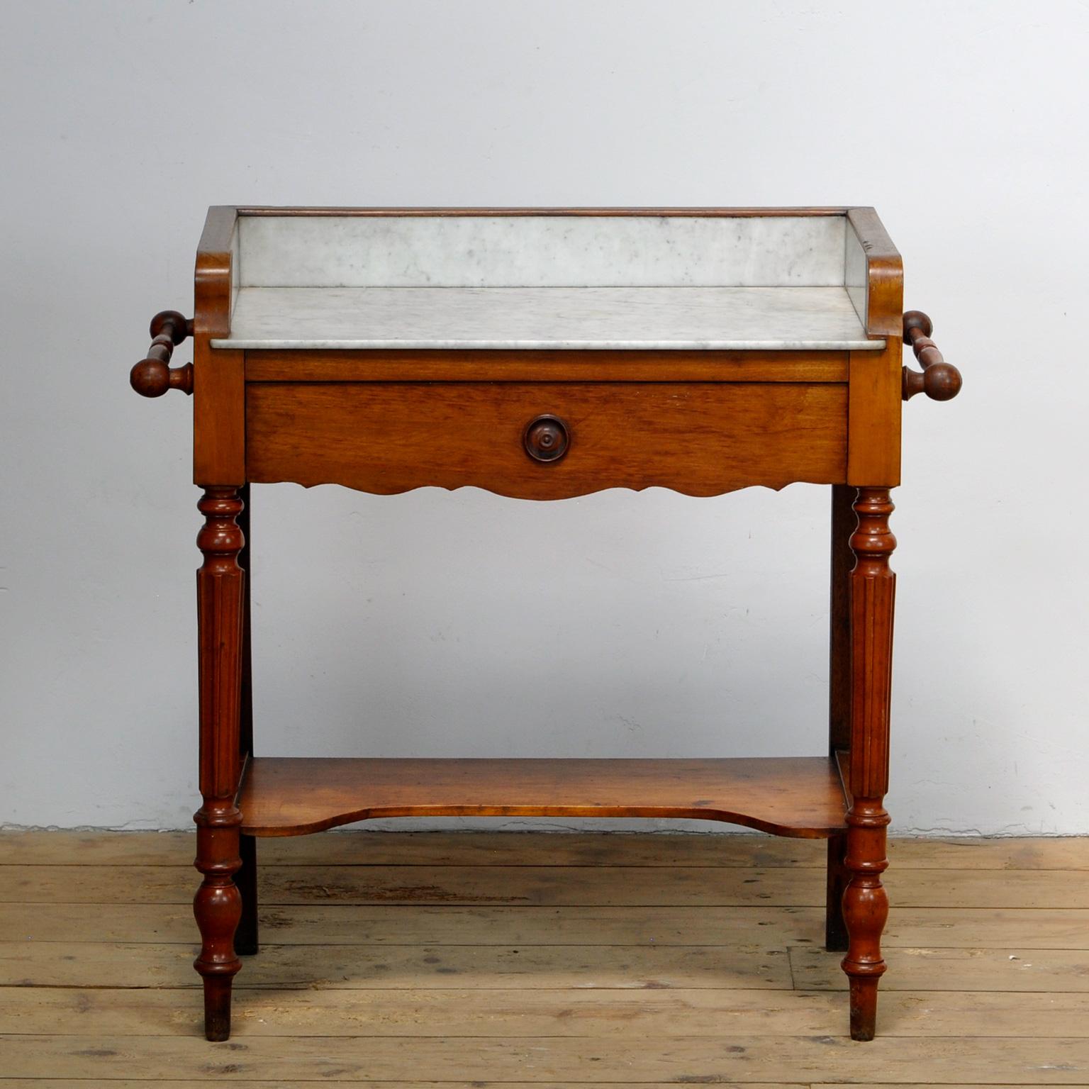  Antique french oak dressing table with marble top with a drawer underneath. A rod on the sides to hang a towel. The cabinet was made around 1920. 