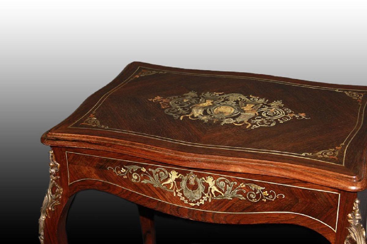 Coiffeuse française de la mi-1800, style Louis XV, en bois de palissandre. Elle présente de riches motifs d'incrustation en ivoire et métal argenté, des applications en bronze également en métal argenté, ainsi que de petits compartiments ouverts à
