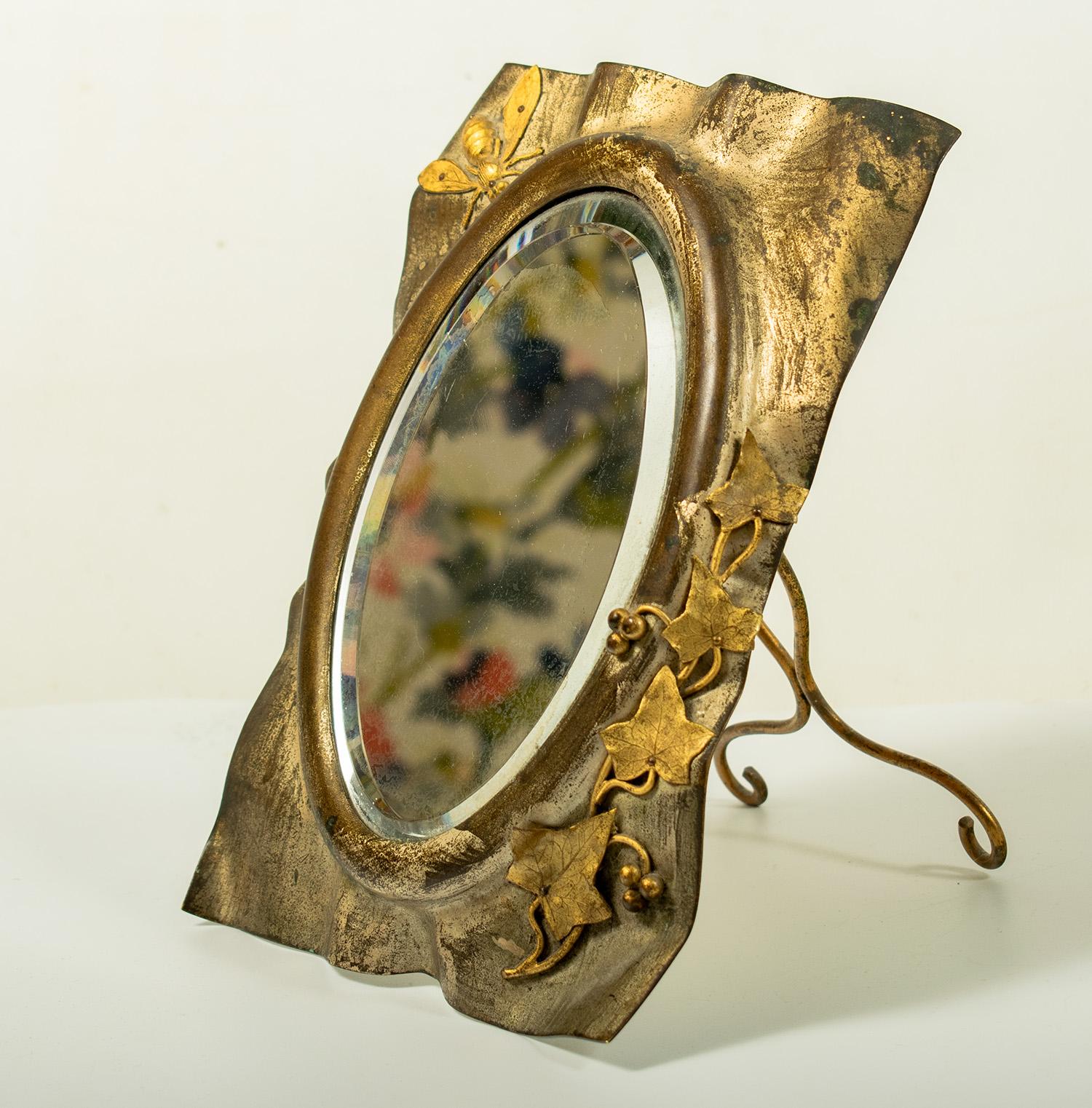Coiffeuse Miroir Art Nouveau - circa 1900

Joli miroir ovale placé dans un cadre rectangulaire, volontairement déformé pour créer une forme organique décorée de feuilles et de tiges de lierre en bas à gauche et d'une abeille en haut à droite.  La