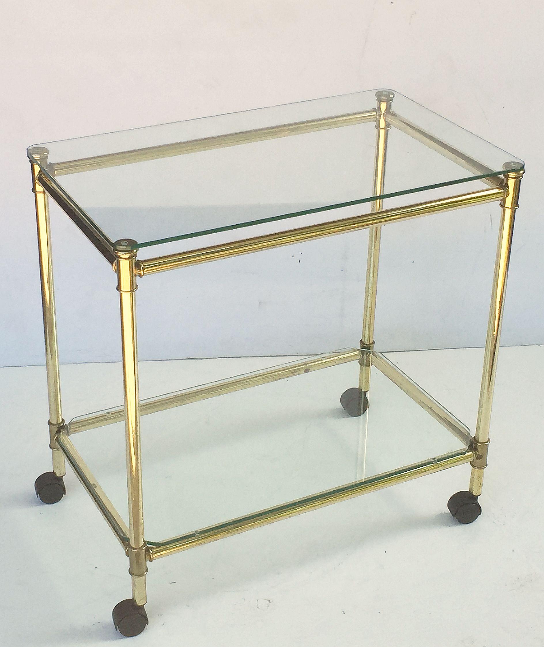 A handsome vintage French rectangular bar cart table or serving trolley in brass, featuring two glass tiers on rolling caster wheels.

Perfect for use as a side or end table.