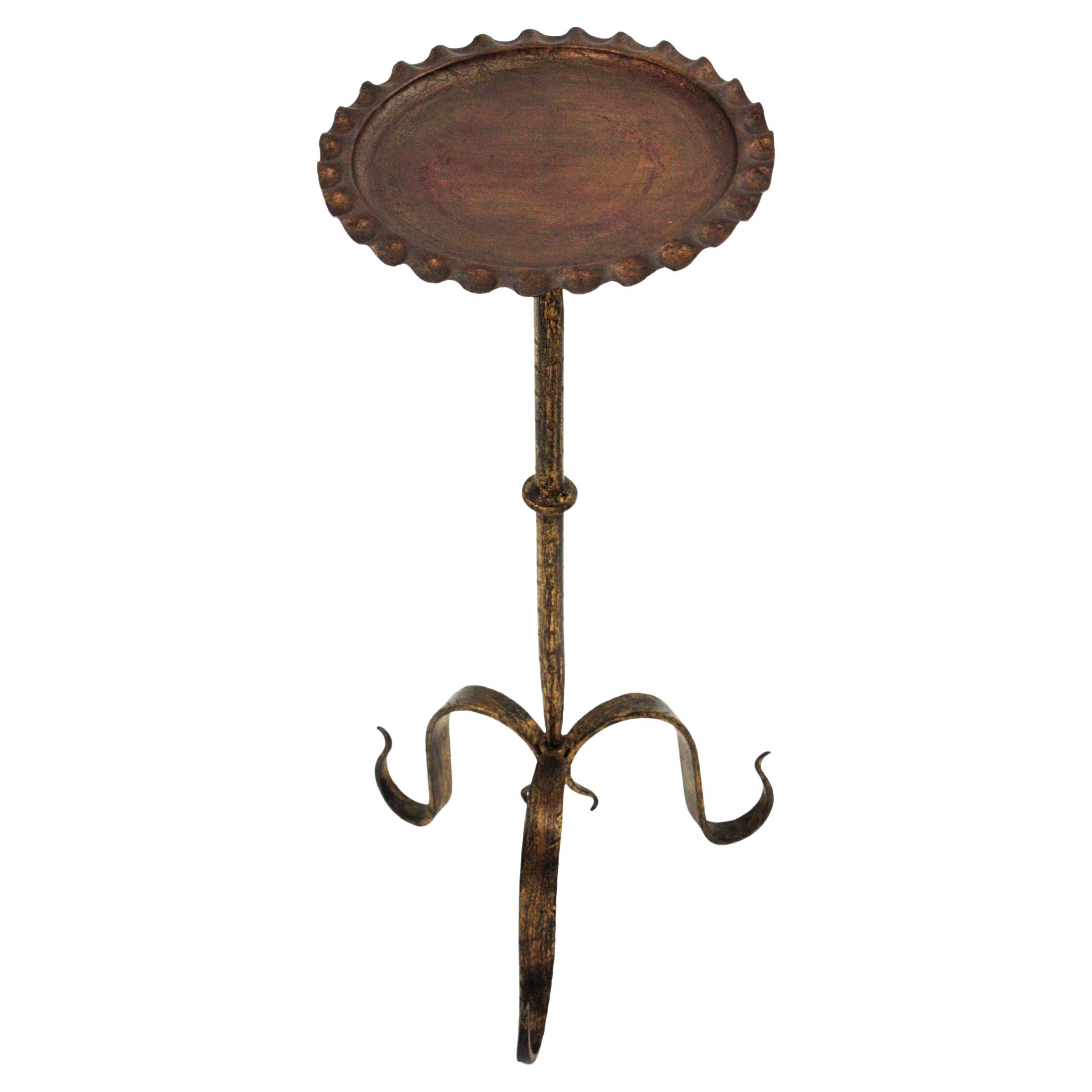 French gilt wrough iron drinks table gueridon, end or side table. Manufactured in France, 1940s.
This pedestal table has a round top with wavy edge heavily decored by the hammer work. It stands on a tripod base with curved scrolled feedt with a