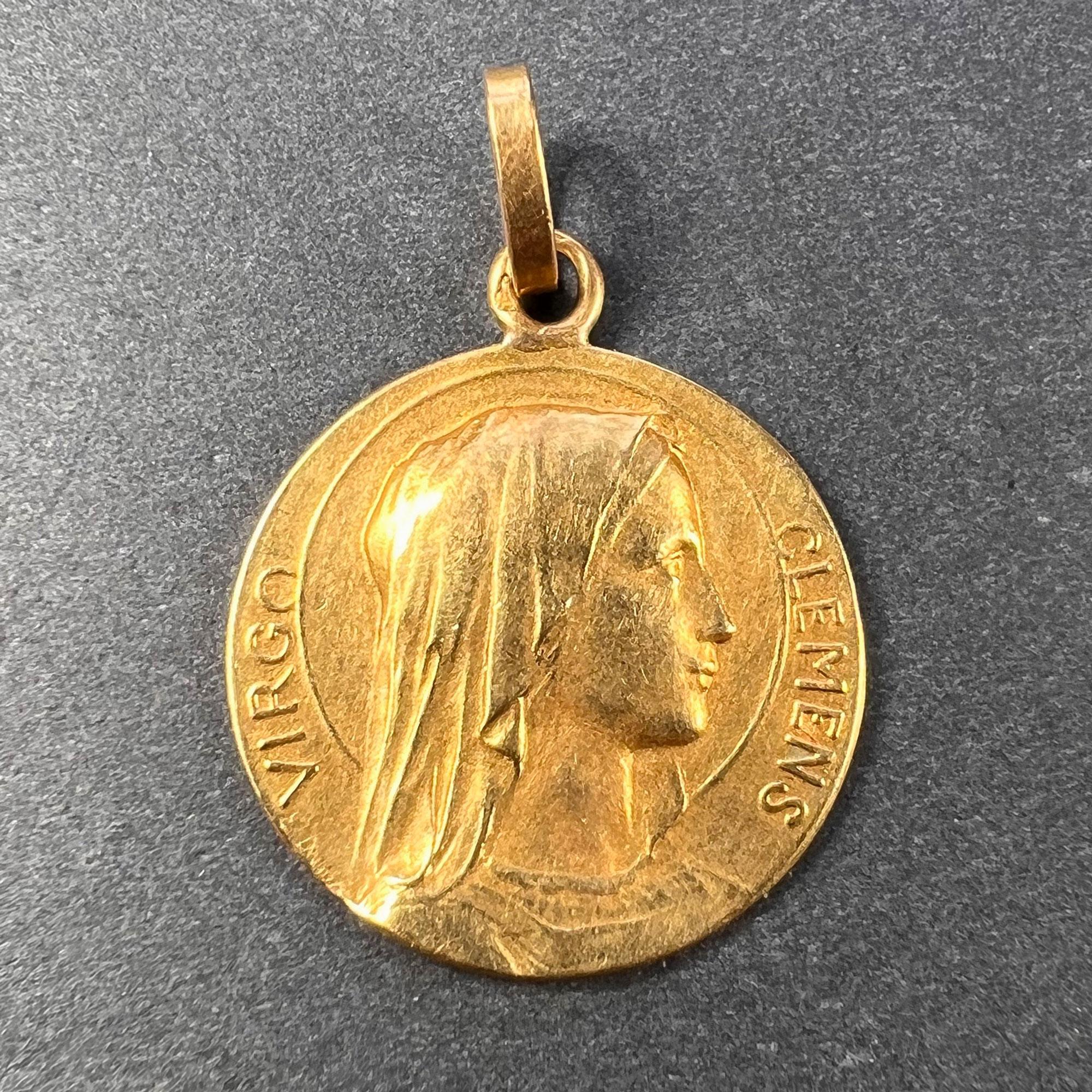 Un pendentif de charme en or jaune 18 carats (18K) conçu comme une médaille représentant la Vierge Marie, avec les mots Virgo Clemens pour Blessed Mother. Signé E. Dropsy, estampillé de la marque de l'aigle pour l'or 18 carats et de fabrication
