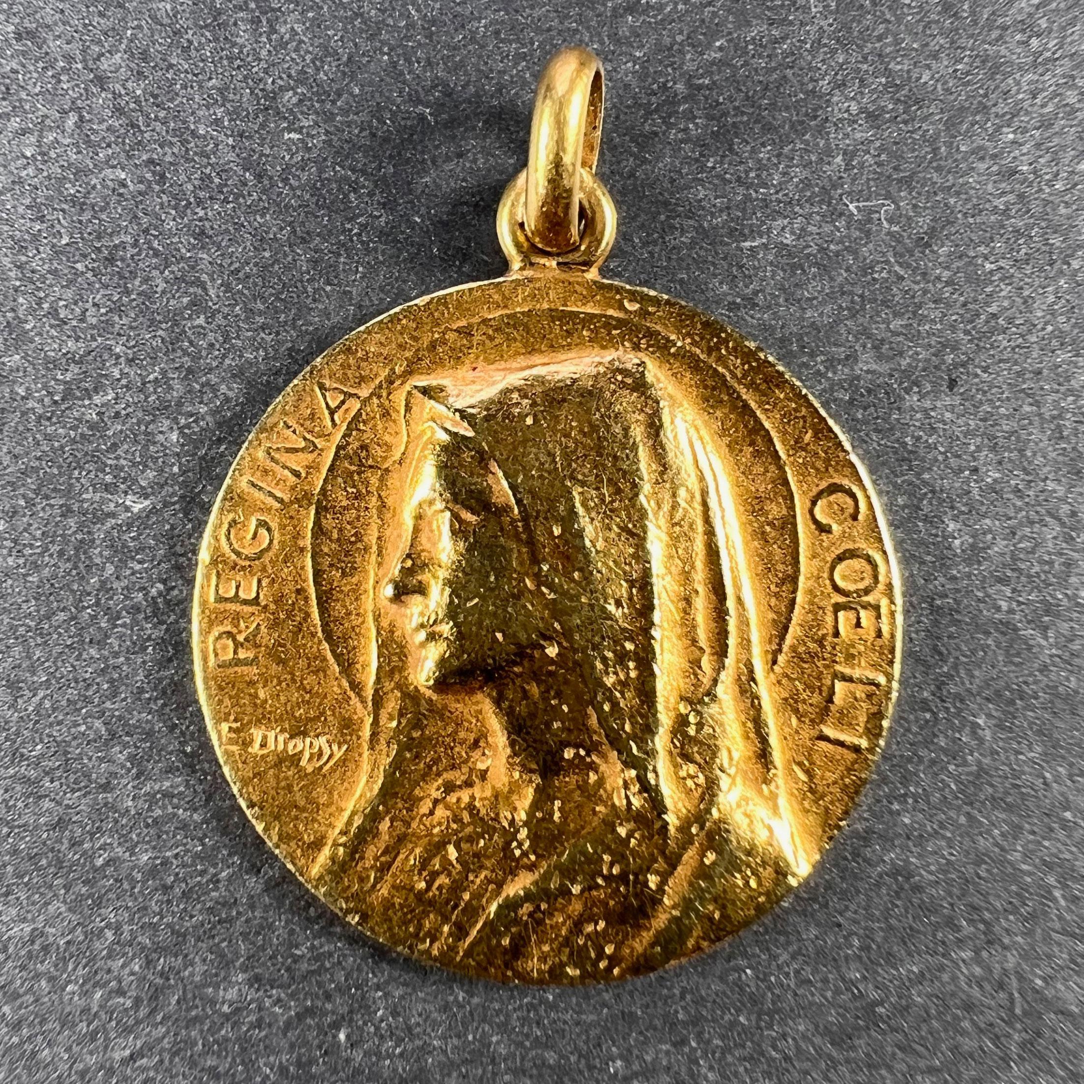 An 18 karat (18K) yellow gold charm pendant designed as a medal depicting the Virgin Mary, detailing the words Regina Coeli for Queen of Heaven. Signed E. Dropsy, stamped with the owl mark for 18 karat gold and French import. The reverse engraved