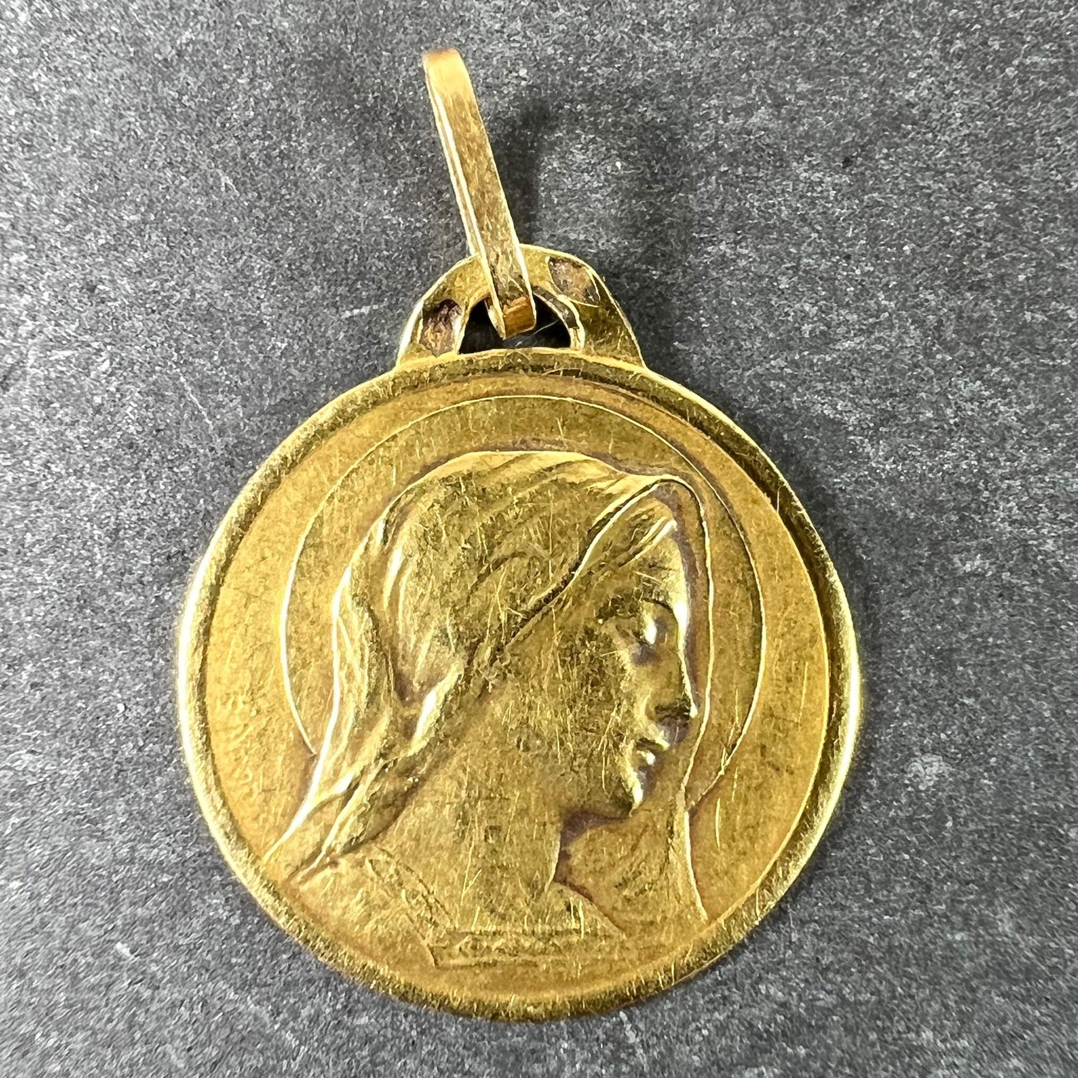 Pendentif à breloques français en or jaune 18 carats (18K) conçu comme une médaille représentant la Vierge Marie dans une auréole. Signée E. Dropsy, estampillée de la marque de l'aigle pour l'or 18 carats et de fabrication française avec une marque