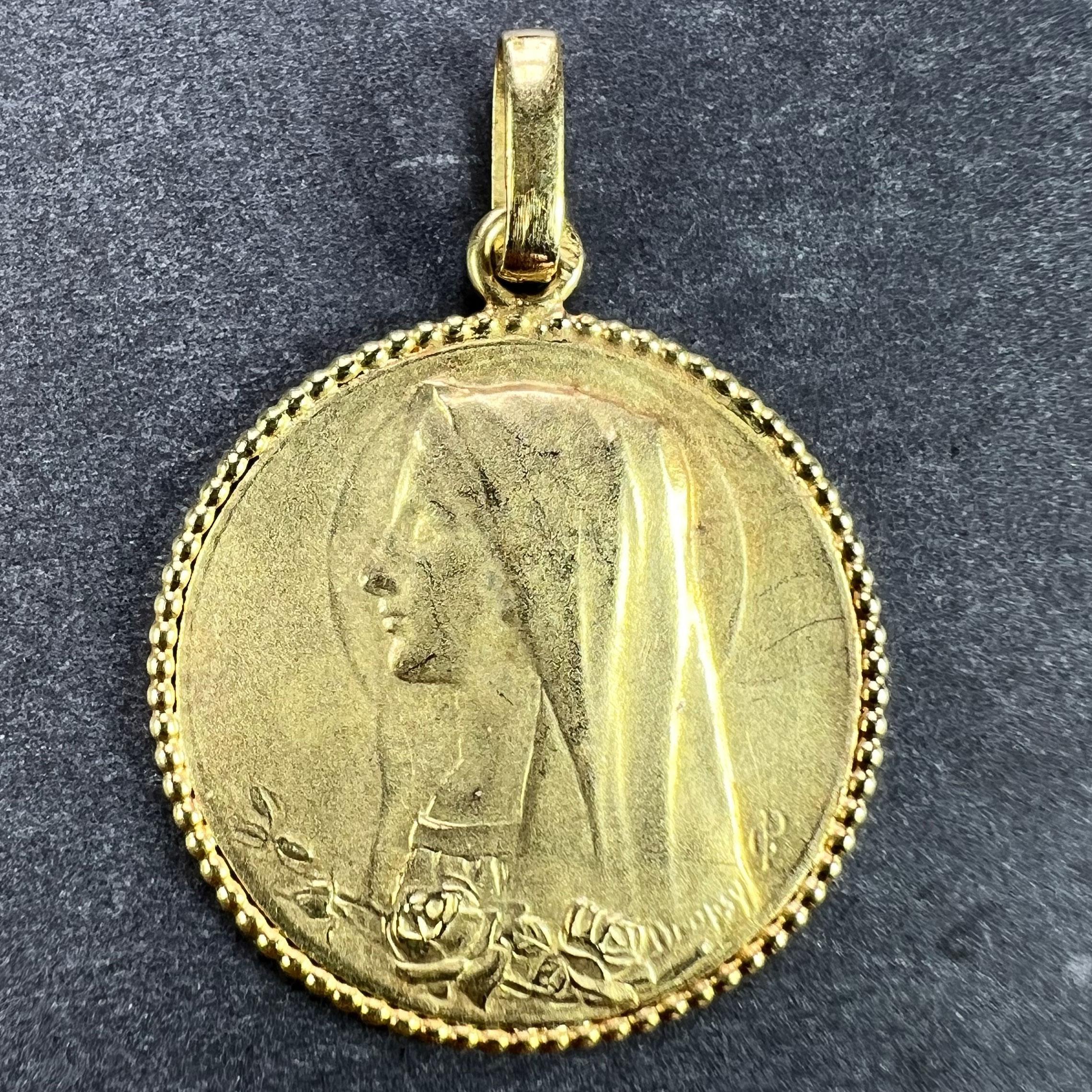 An 18 karat (18K) yellow gold pendant designed as a round medal depicting the Virgin Mary with a halo and a sheaf of roses below. Signed E. Dropsy. Stamped with the eagle's head for French manufacture and 18 karat gold.

Dimensions: 2.2 x 2 x 0.1 cm