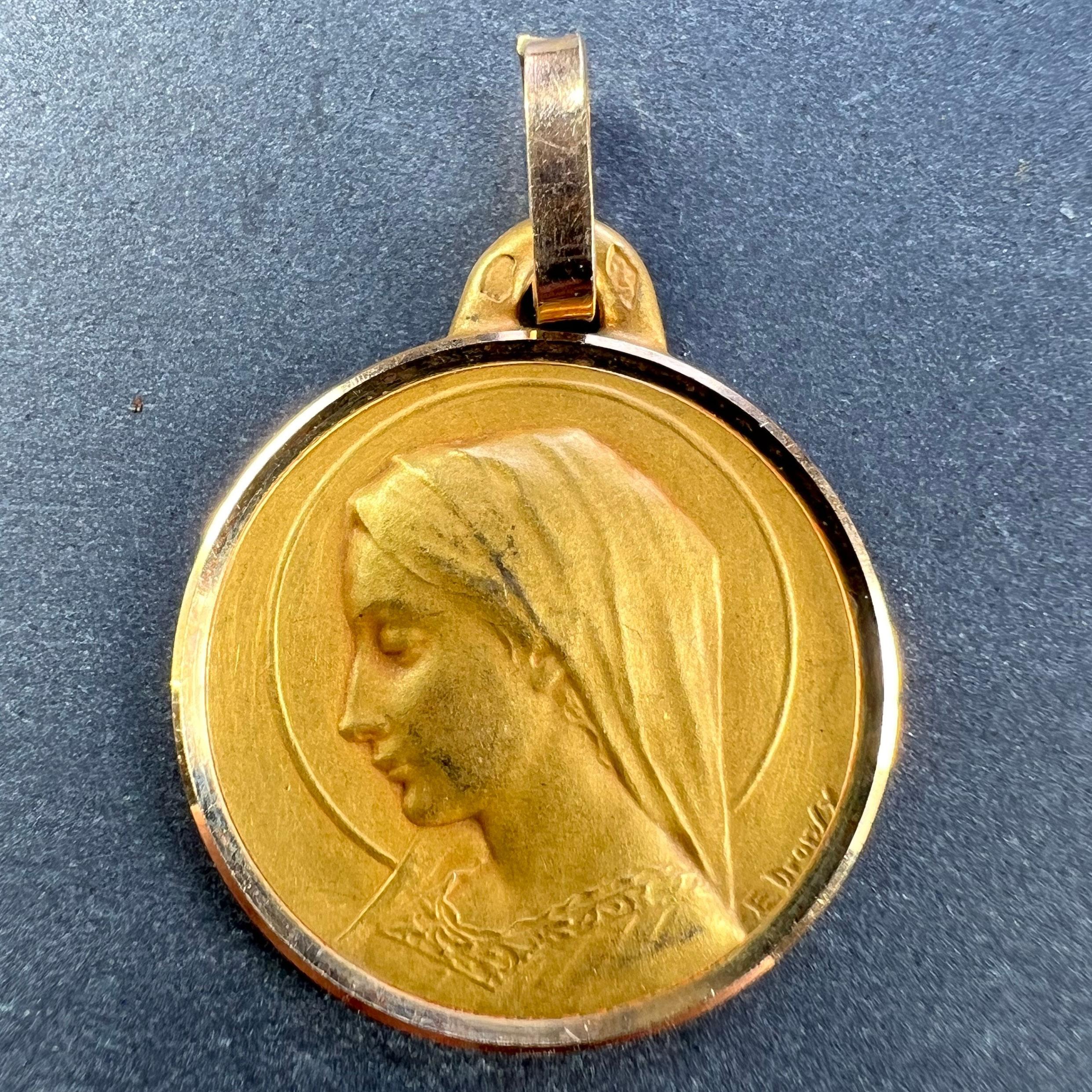A French 18 karat (18K) yellow gold pendant designed as a round medal depicting the Virgin Mary within a halo. Signed E. Dropsy. Stamped with the eagle’s head for French manufacture and 18 karat gold, with maker’s mark for Perriat.

Dimensions: 2.2