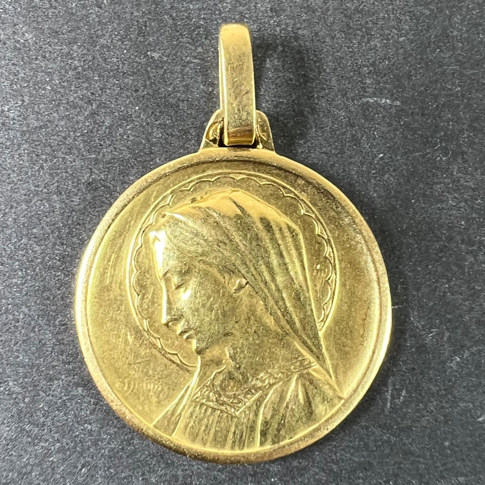 A French 18 karat (18K) yellow gold pendant designed as a round medal depicting the Virgin Mary within a halo. Signed E. Dropsy. Stamped with the eagle’s head for French manufacture and 18 karat gold, with maker’s mark for Perriat. Engraved to the