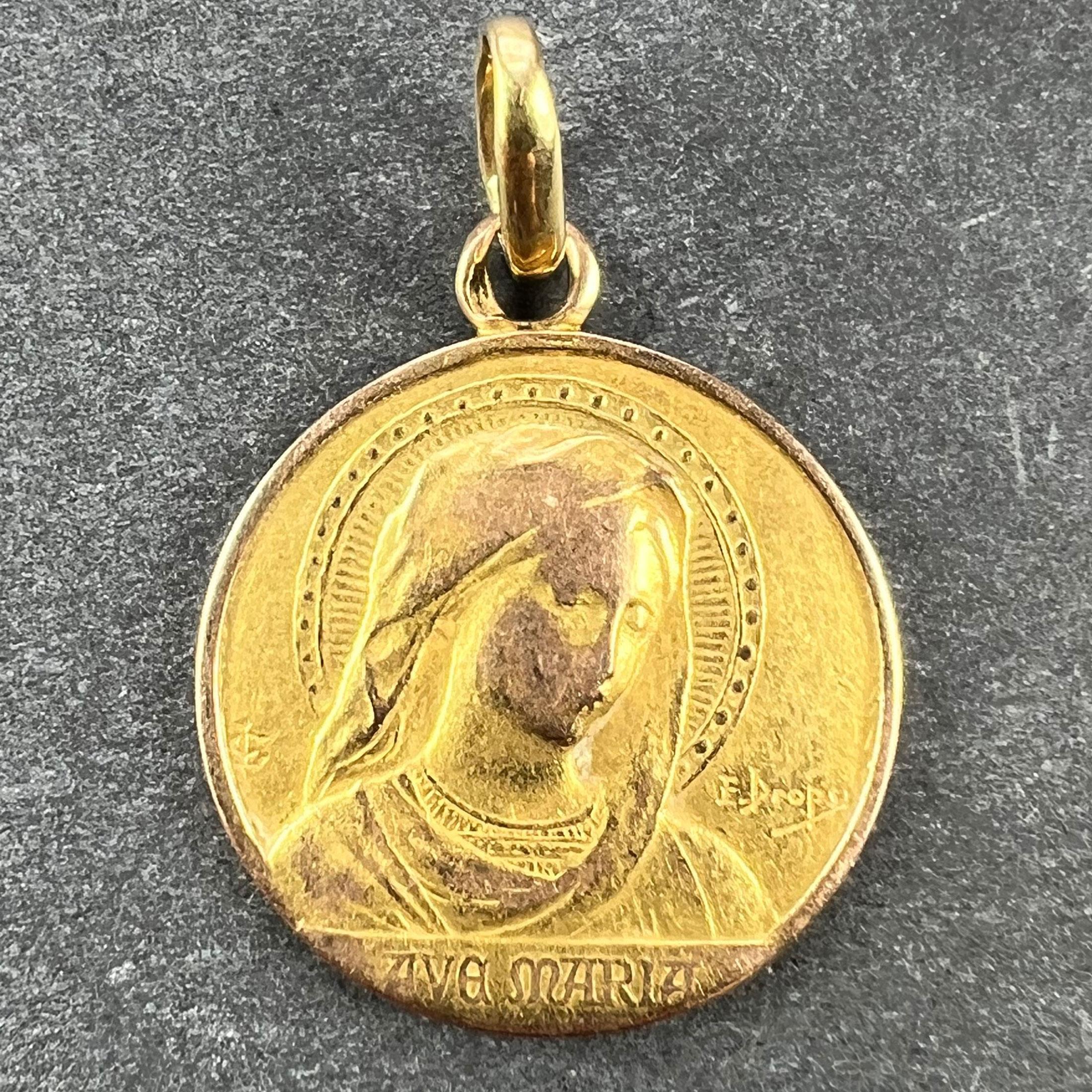 Un ciondolo charme in oro giallo 18 carati (18K) disegnato come una medaglia che raffigura la Vergine Maria con un'aureola e la scritta Ave Maria. Firmato E. Dropsy, timbrato con il marchio dell'aquila per l'oro a 18 carati e di manifattura francese