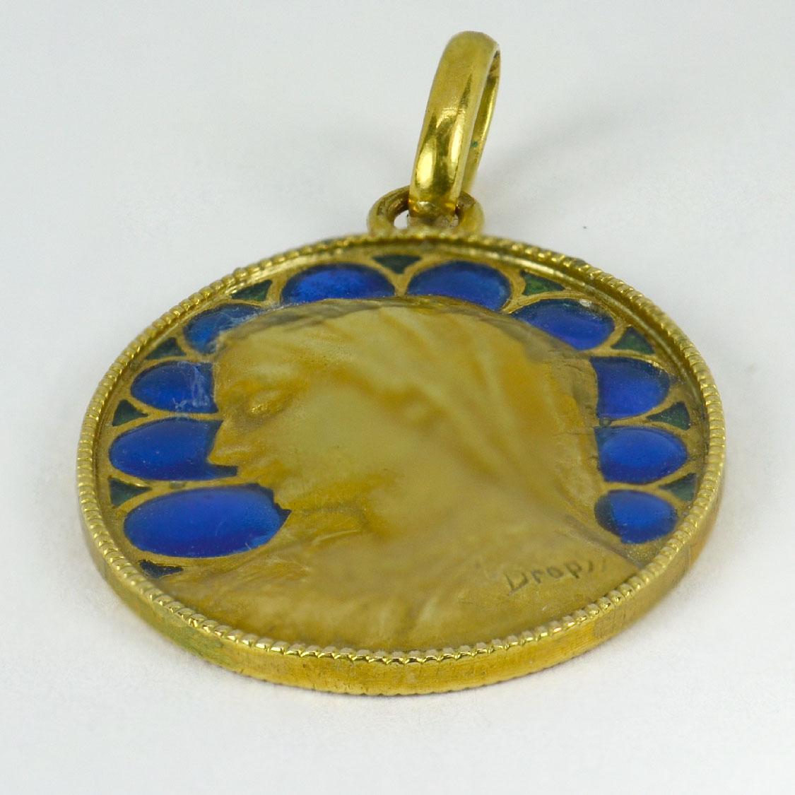 A French 18 karat (18K) yellow gold charm pendant depicting the Virgin Mary with blue and green plique a jour enamel. Signed Dropsy, stamped with the French eagle’s head for 18 karat gold and partial makers mark.

Dimensions: 2.6 x 1.8 x 0.15