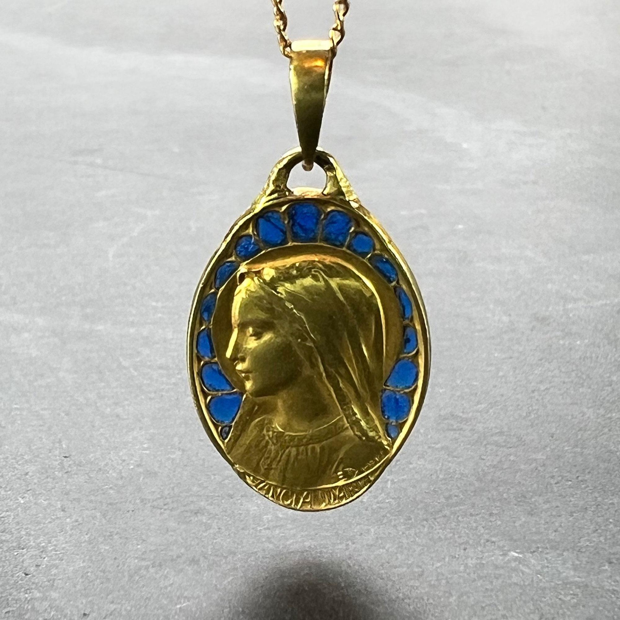 Pendentif de charme français en or jaune 18 carats (18K) conçu comme une médaille ovale représentant la Vierge Marie avec un entourage d'émail bleu plique a jour, sur les mots 