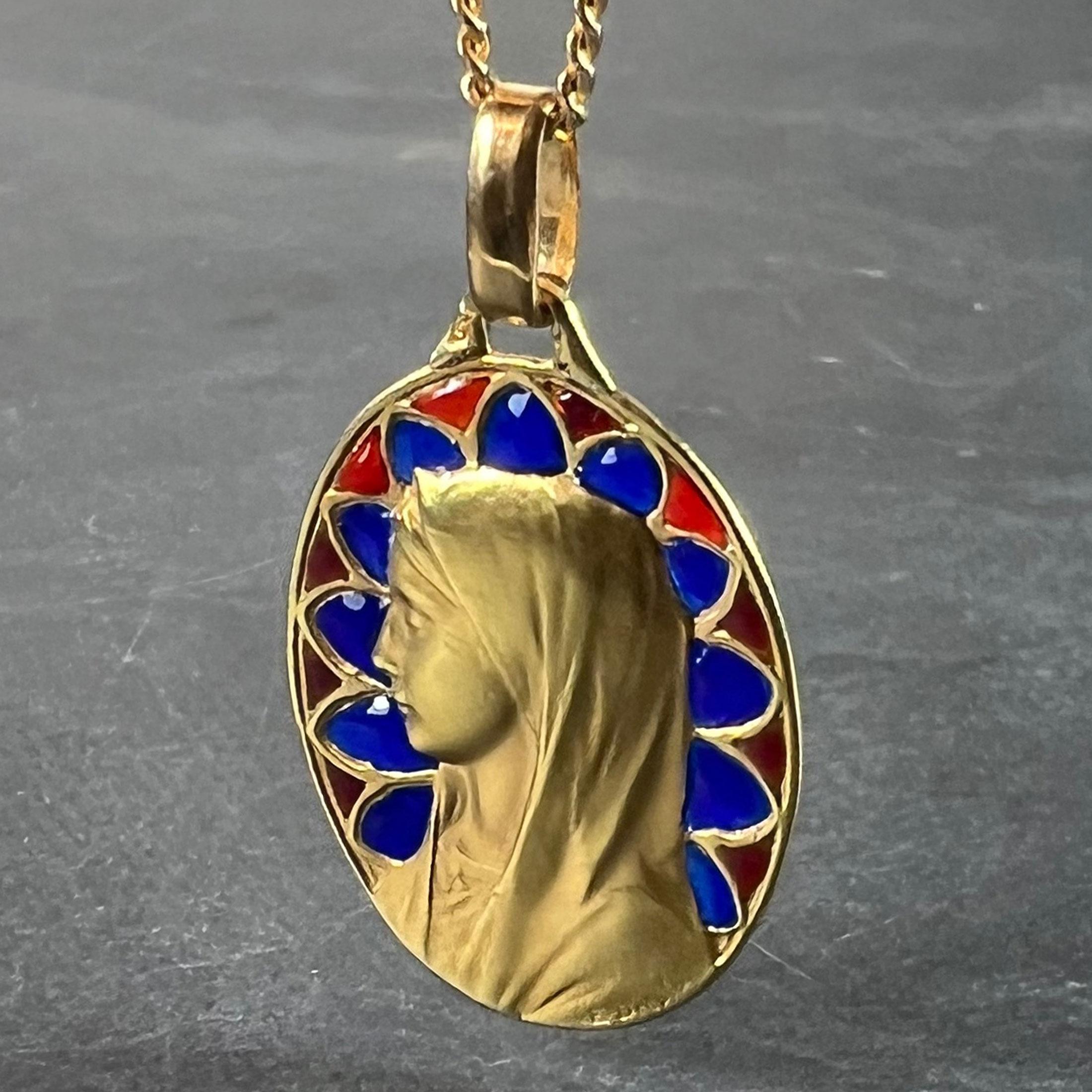 A French 18 karat (18K) yellow gold charm pendant designed as an oval medal depicting the Virgin Mary with plique-a-jour red and blue enamel surround designed as a radiant set of gothic arches. Signed E Dropsy, stamped with the eagle’s head for 18