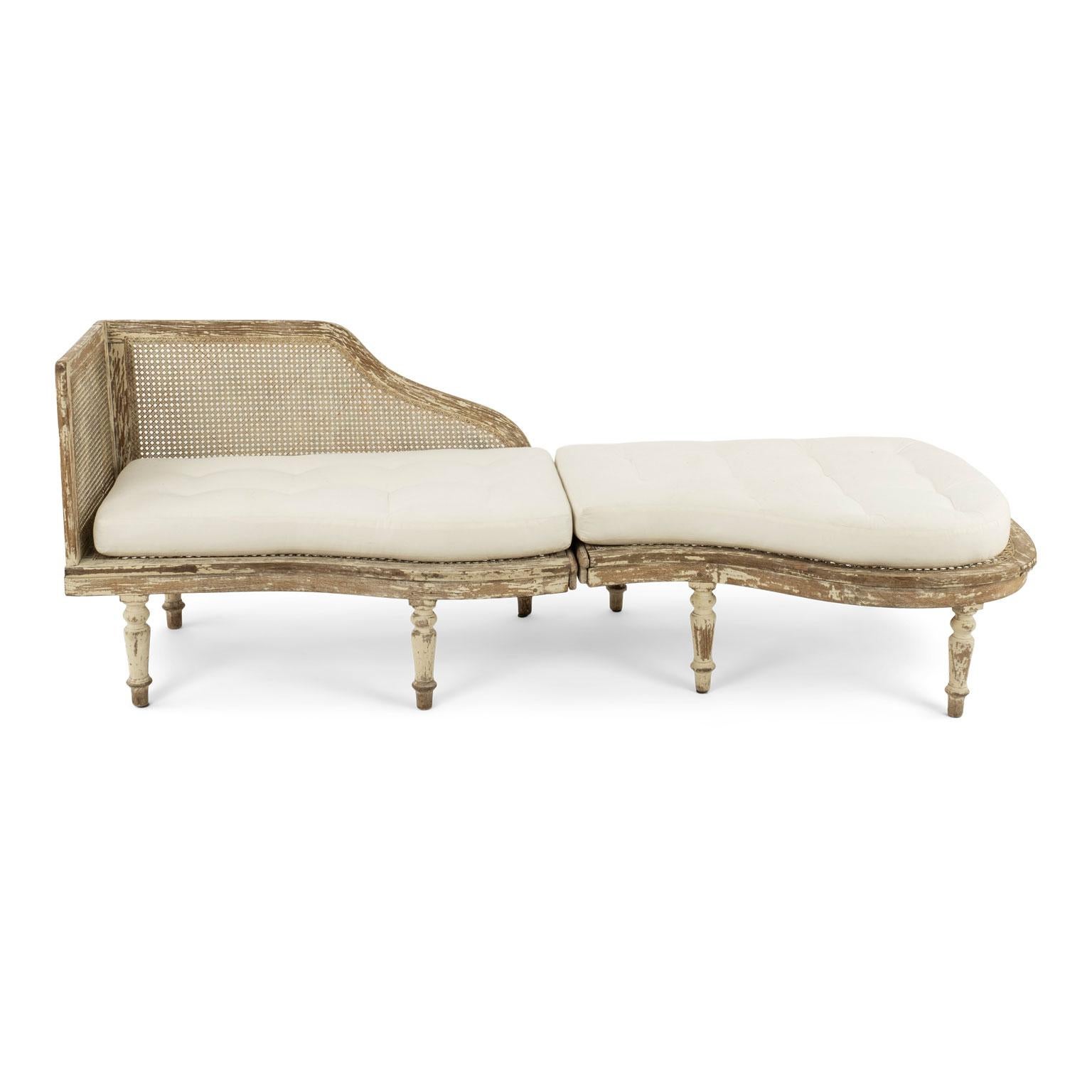 French duchesse brisée (circa 1930-1950) in light green-beige paint. Two piece chaise longue with caned seat and back. Remnants of original or early paint decorate its surface. This two-piece chaise includes newly-made tufted cushions.

Note: