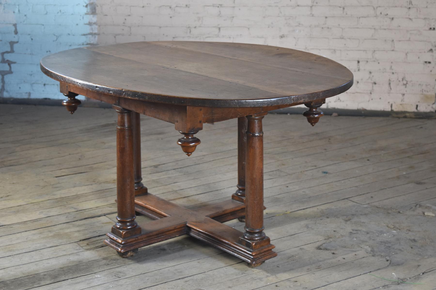 French Henry IV oval center, dining or breakfast table, early 17th century, of rare form and conceptual design, solid walnut with wonderful, deep patina.
The oval top, consisting of three boards, over a rectangular frieze adorned with drop-finials