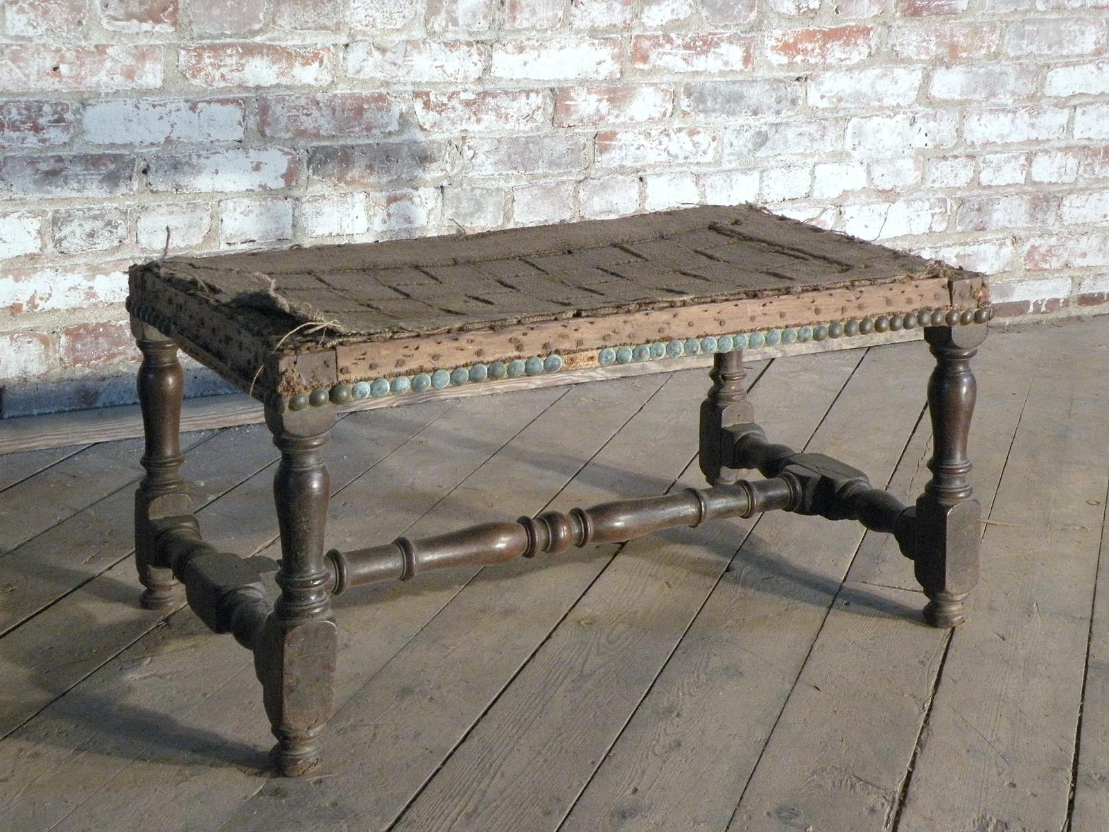 French early 18th Century Baroque Bench or Footstool of elongated proportions. Walnut frame with nicely turned legs and conforming H-stretcher, good color with deep patina. Solid pegged construction. The stool can be seen in person at the Fortress