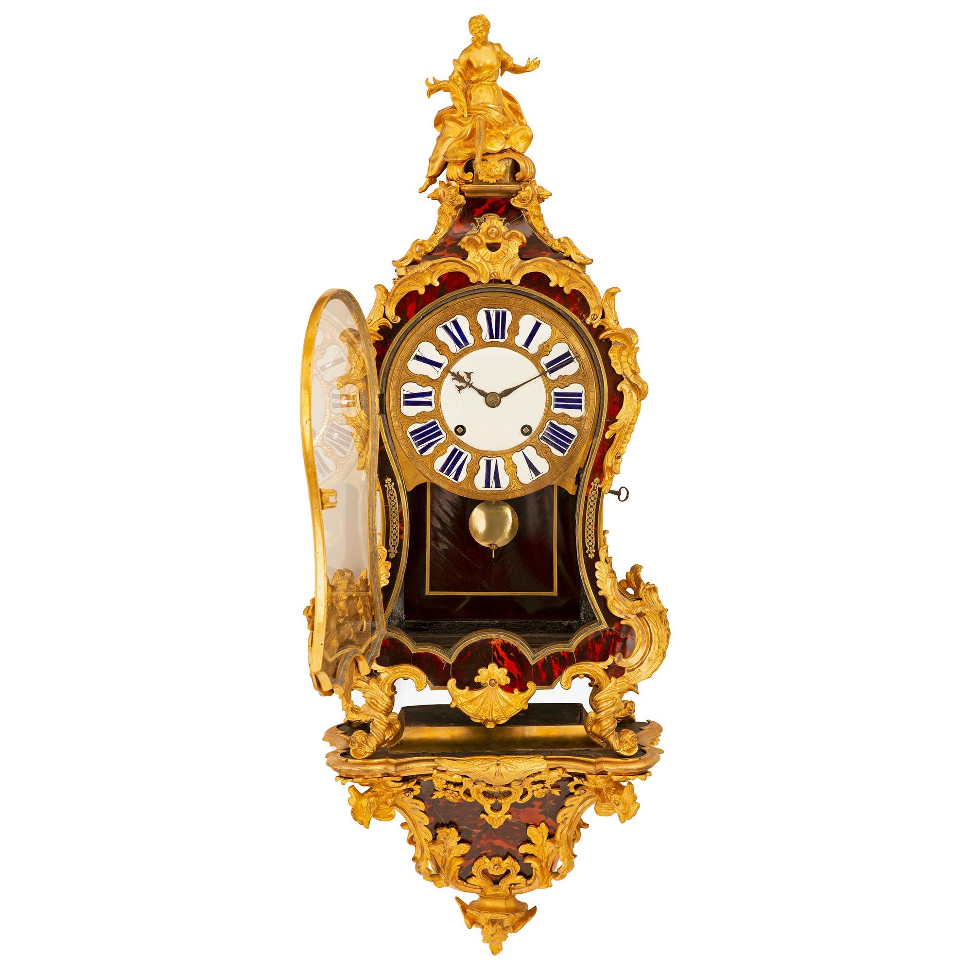 A spectacular and extremely high quality French early 18th century Louis XV period tortoise shell and ormolu mounted Cartel clock. The impressive clock rests on its original wall mounted bracket with a bottom ormolu finial of an owl below four 'S'