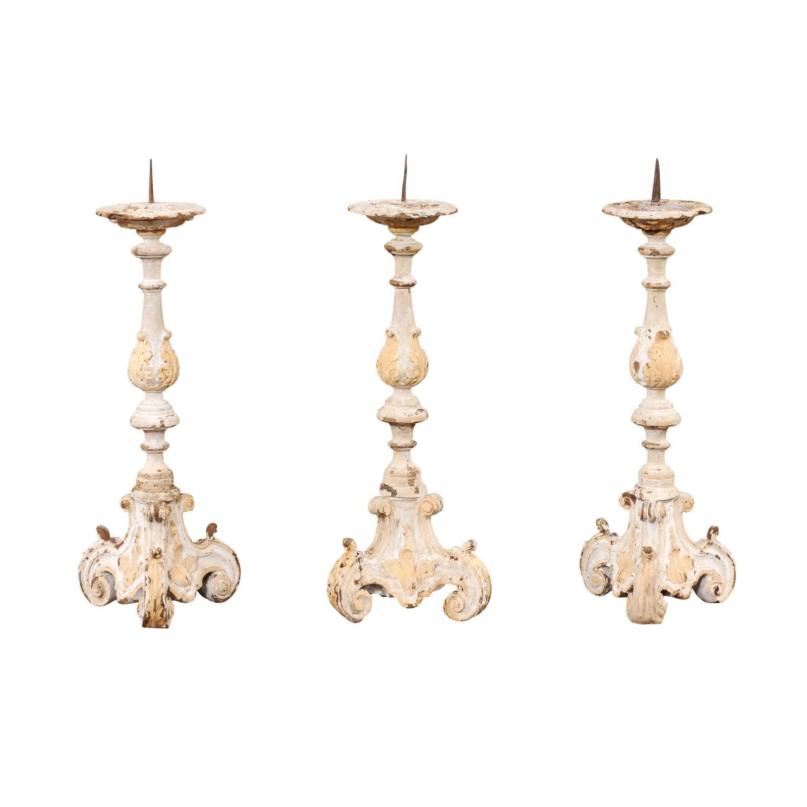 French Rococo period early 18th century two tone light gray and cream painted candlesticks, with authentic patina, priced and sold each. Discover the allure of the French Rococo period with these early 18th-century candlesticks, each presenting a