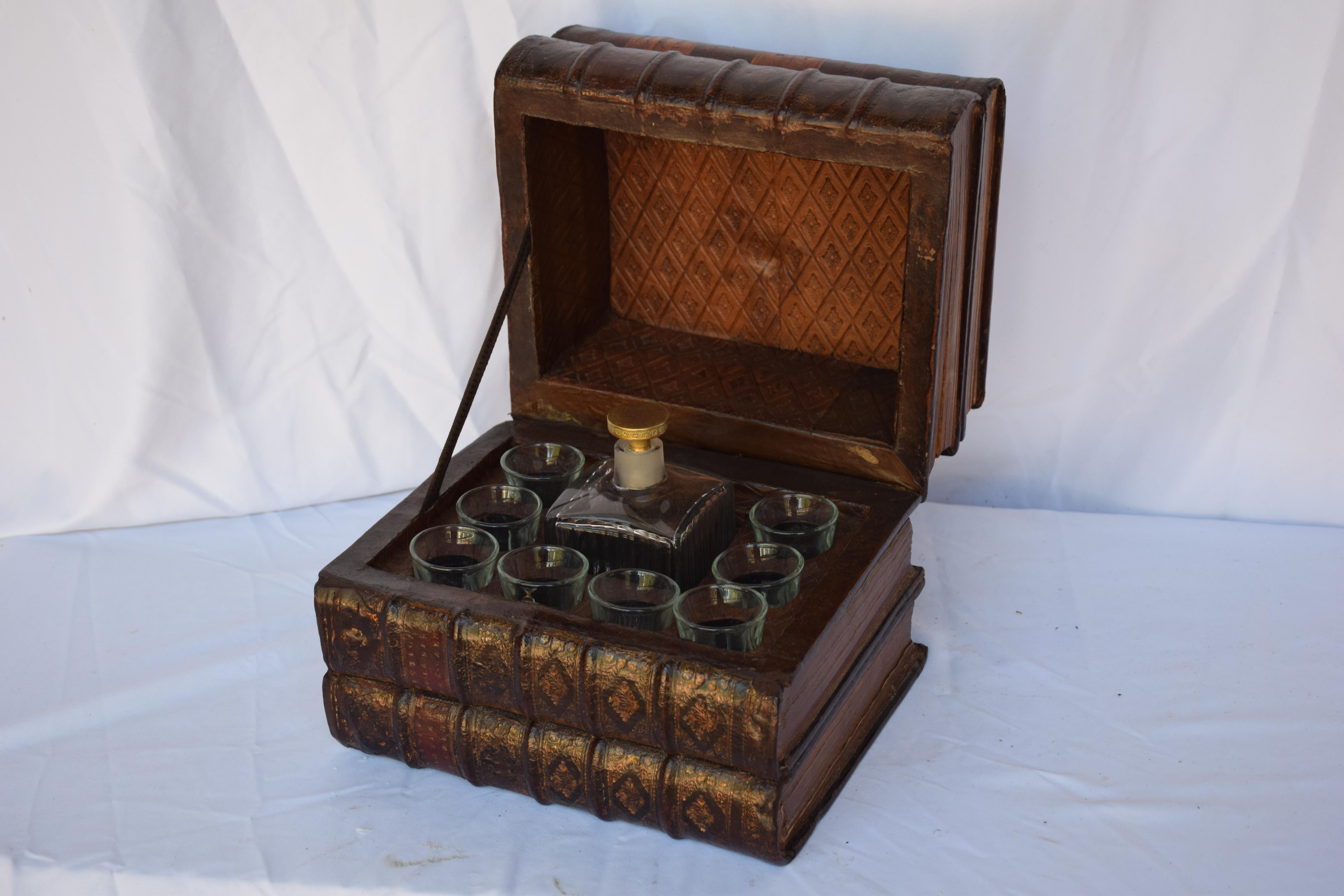 Unique little box to discreetly keep your fancy liquor!!!  The early 1900s French box, a stack of 4 leather-bound books, reveals a fitted interior for a small glass stoppered bottle and 8 shot glasses.  The faux book bindings have gilt decorations