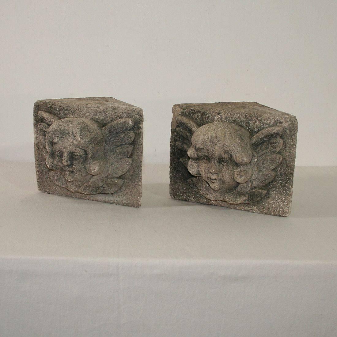 Beautiful pair of hand-carved stone winged angel head ornaments, France, circa 1800-1850. Weathered.