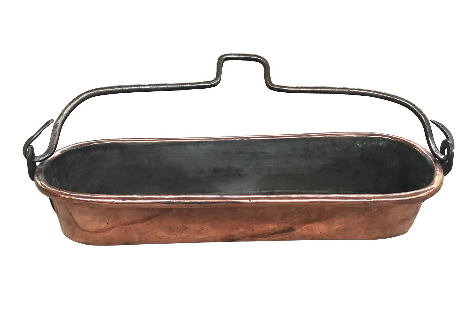 A very charming early 19th century fish pan beautifully crafted from copper and an iron handle. This beautiful piece origins from the southwest of France. Perfect as a kitchen accessory or for any table top.