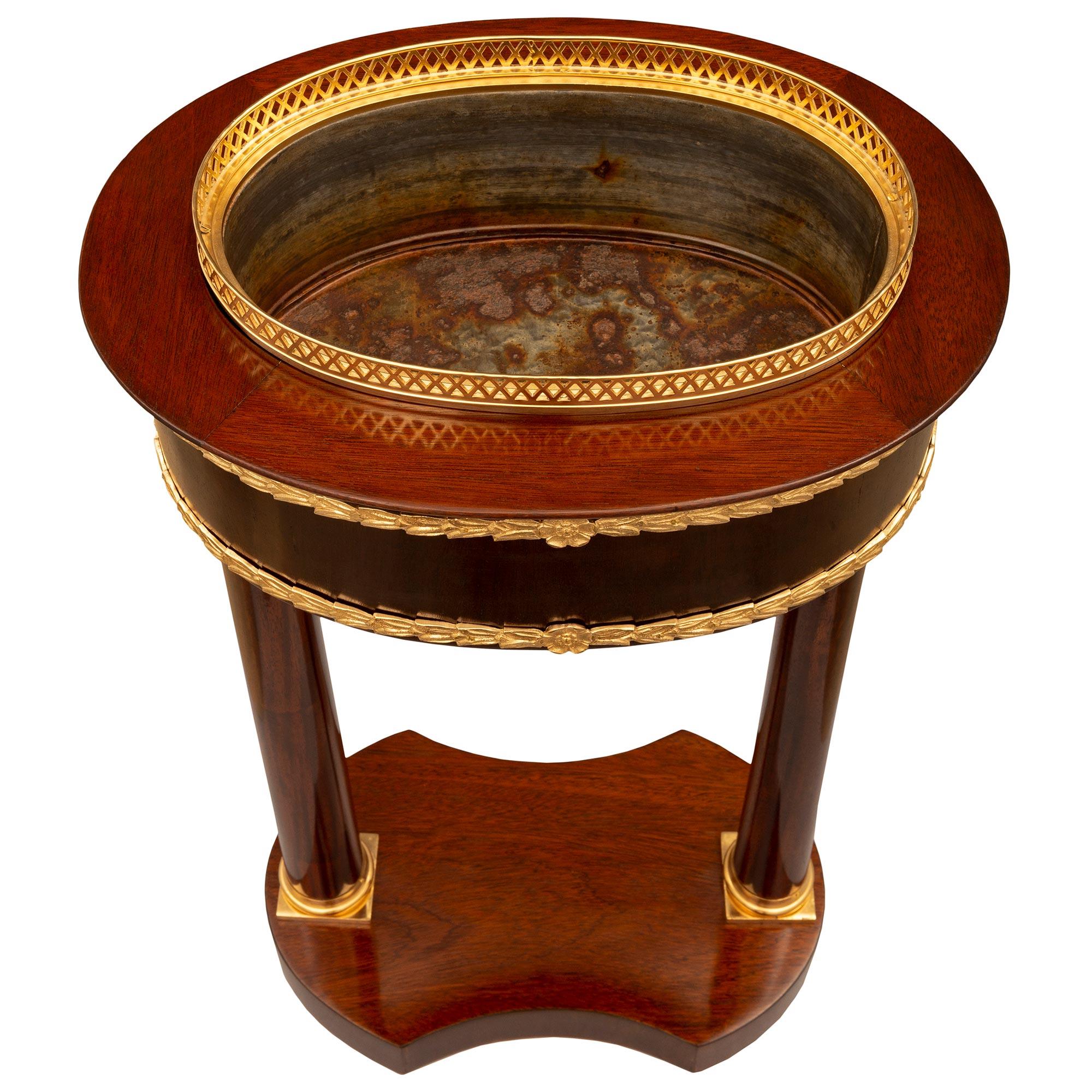 An exceptional and most decorative French early 19th century Directoire st. Mahogany and ormolu jardiniere planter circa 1805. The planter is raised by an elegant bottom tier with fine concave front and back and lovely rounded sides. Two impressive