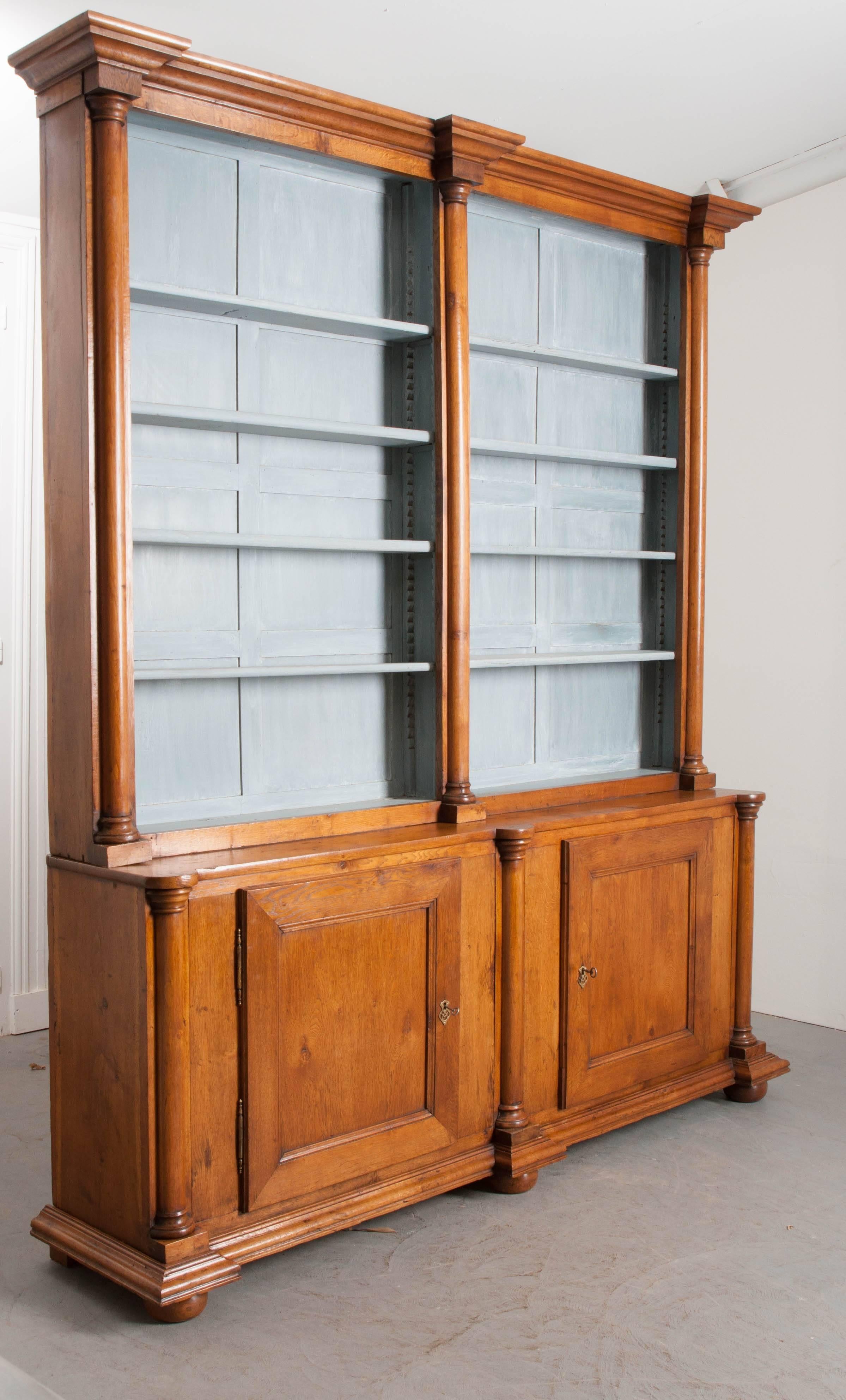 A breathtaking bookcase, made of solid oak, from the beginning of the 19th century, England. The bookcase has two bodies: an upper, shelved unit, and a lower case body. The upper is outfitted with eight shelves, which can all be adjusted to suit