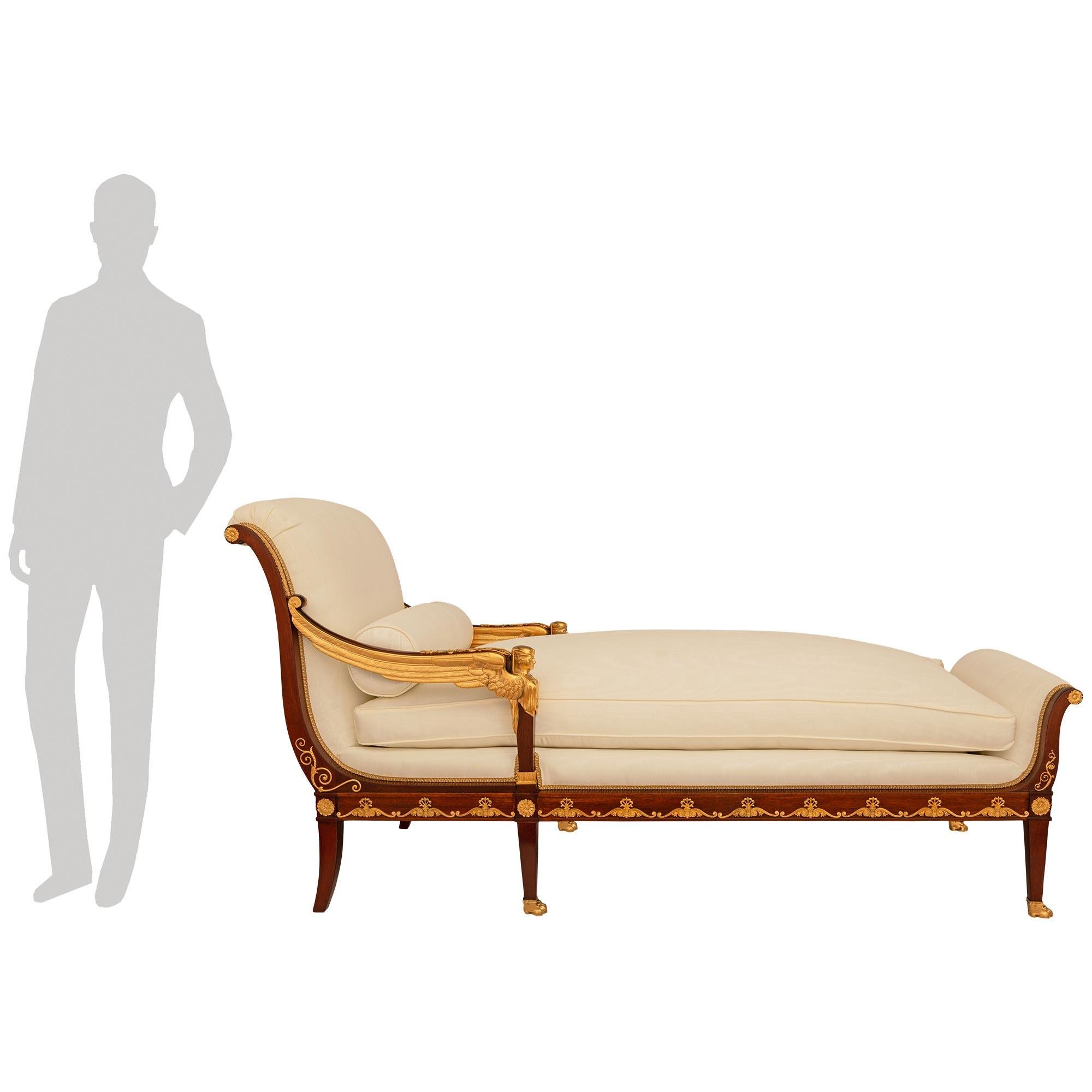 An elegant and most decorative French early 19th century Empire period Mahogany and Ormolu chaise, Circa 1805. This exquisite chaise is raised by six elegant Mahogany legs  with Ormolu paw feet supporting the front and central legs with curved