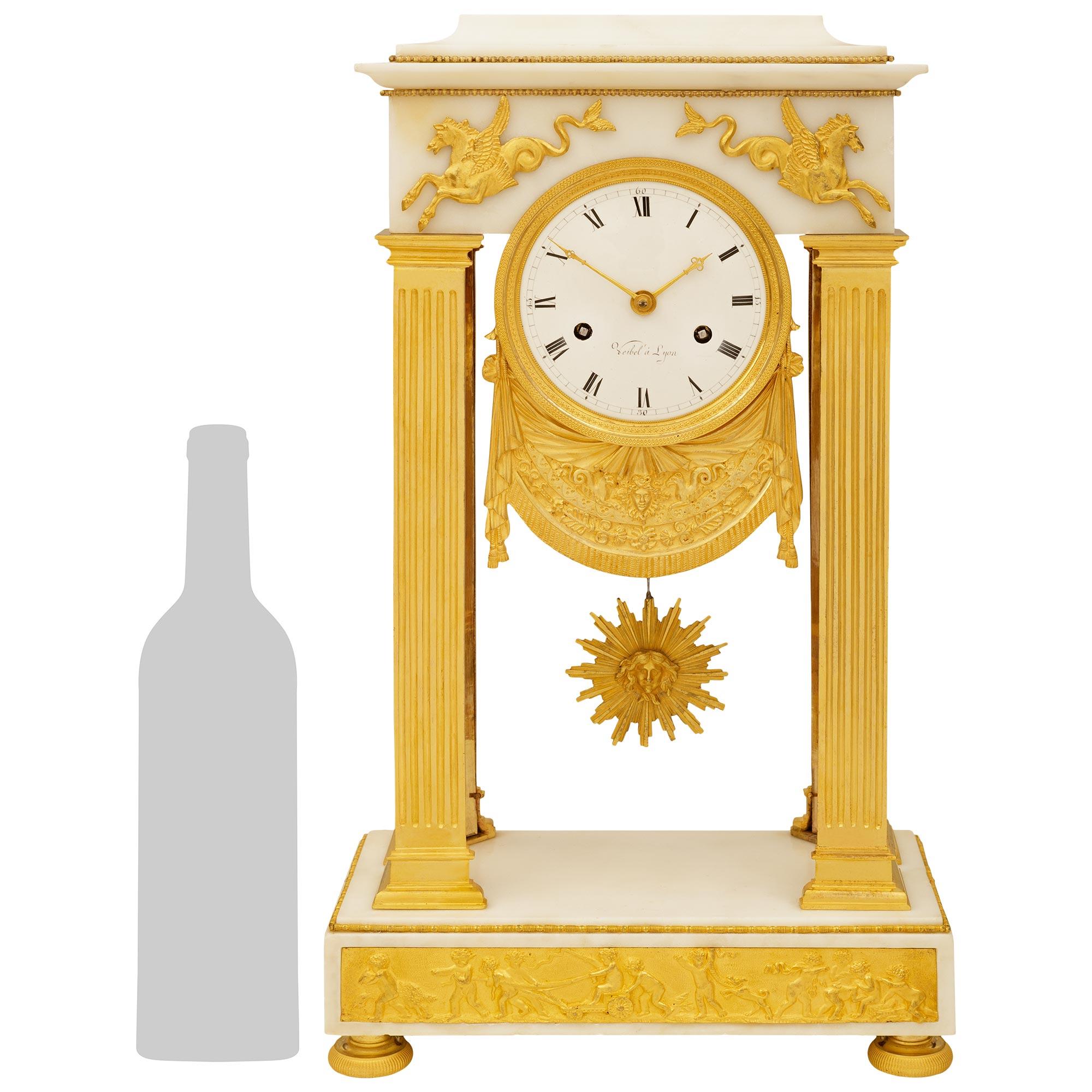 A charming and high quality French early 19th century Empire st. white Carrara marble and Ormolu clock, signed Veibel a Lyon. This stunning clock is raised on Ormolu topie shaped feet supporting a rectangular marble base. The base is decorated with