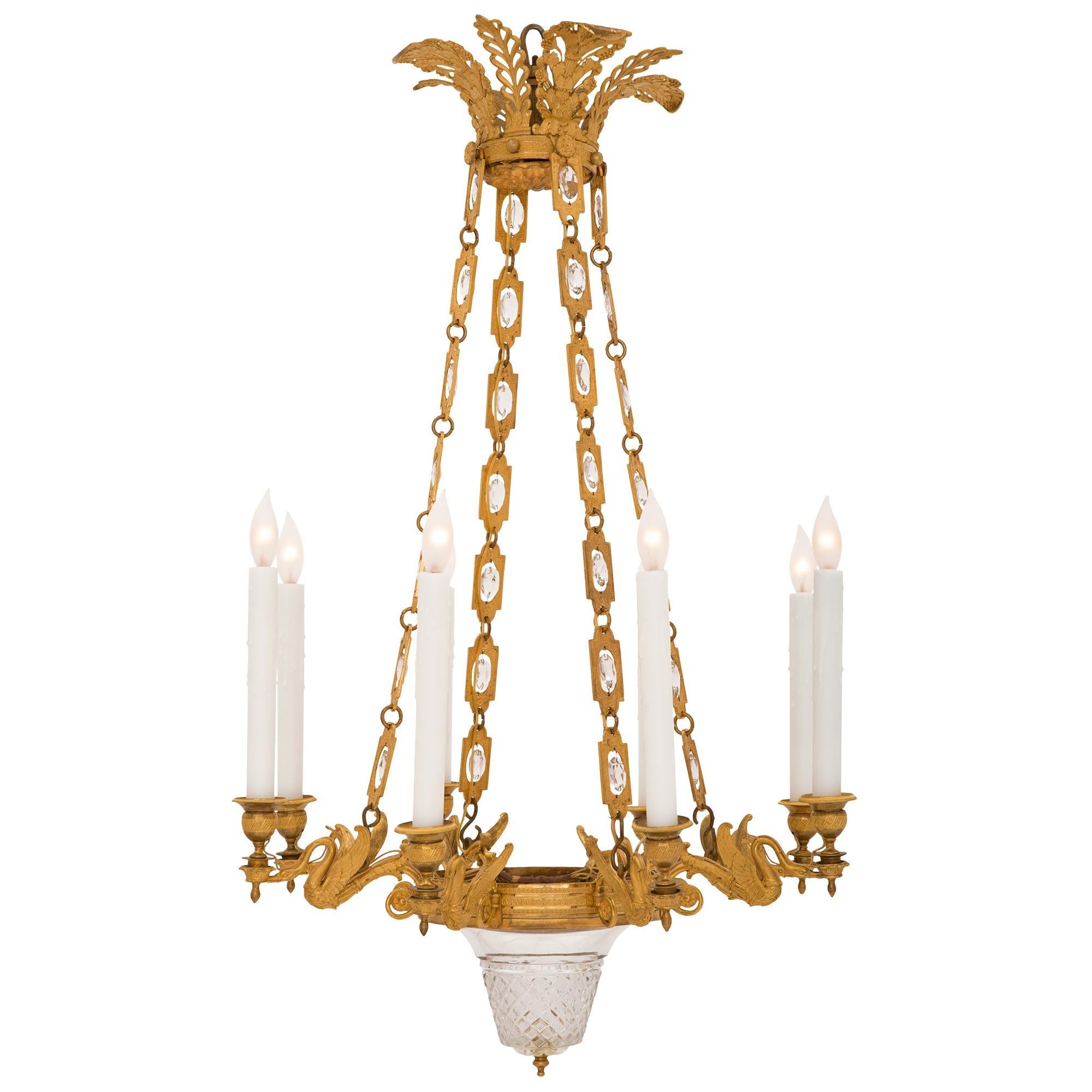 A stunning and extremely high quality French early 19th century 1st Empire period ormolu and Baccarat crystal chandelier, circa 1805. The eight arm chandelier is centered by a striking and most decorative Baccarat crystal bowl with a fine topie