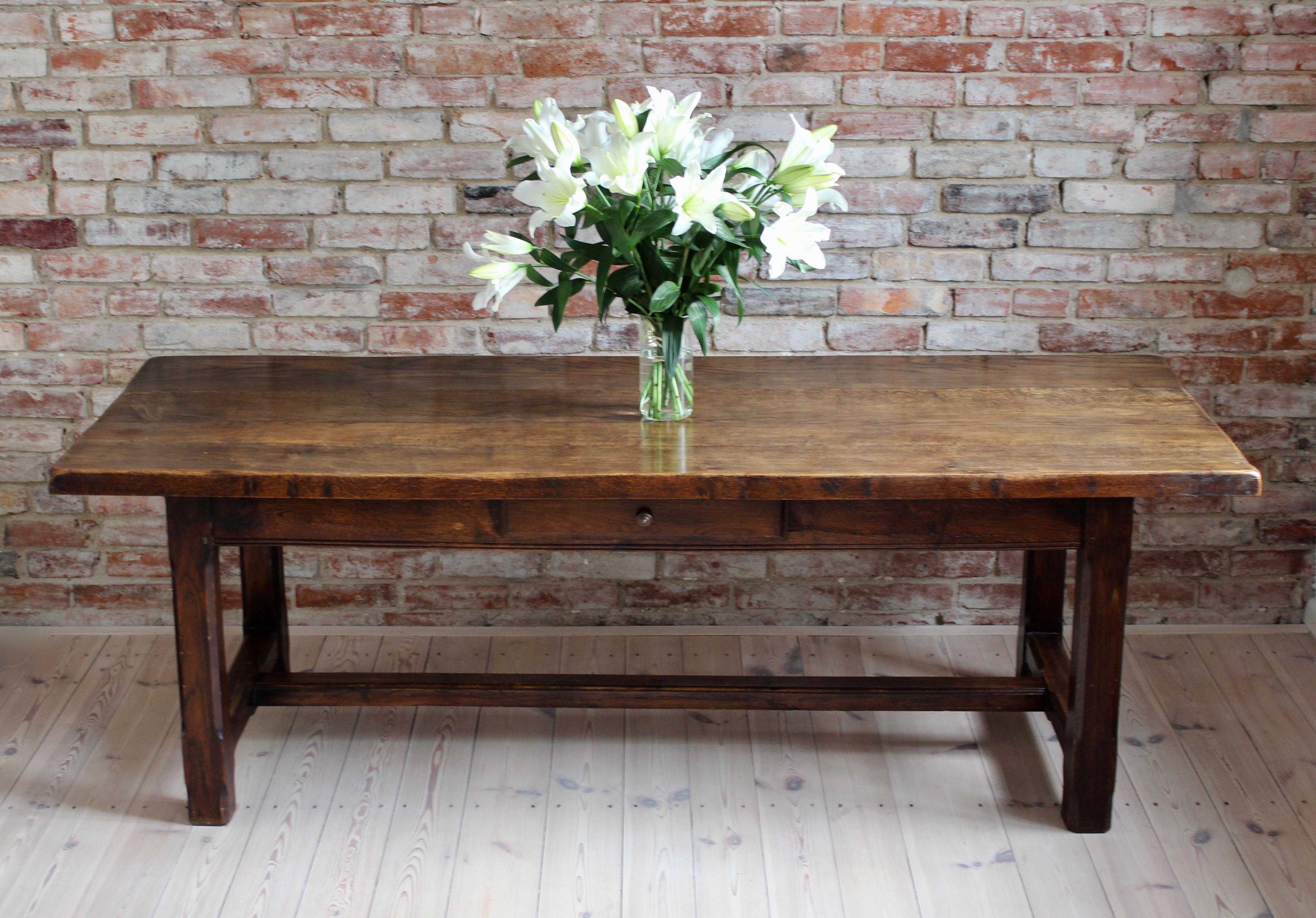 This gorgeous farm table was made in France, circa 19th/20th century. It has acquired some unique patina over years of use and hundreds of family gatherings. Four wide, oak boards comprise the table’s top, fixed together with pegs and holes joinery