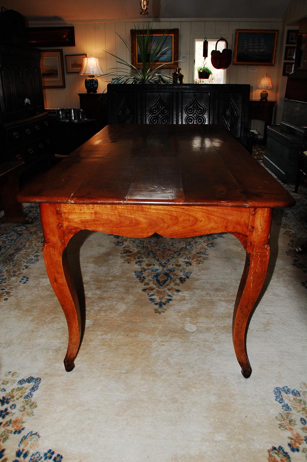 French provincial cherry farmhouse table with graceful cabriole legs, single end drawer, shaped skirt all around. This early 19th century table was crafted using the time honored mortise, tenon and peg method of construction. We have modified the
