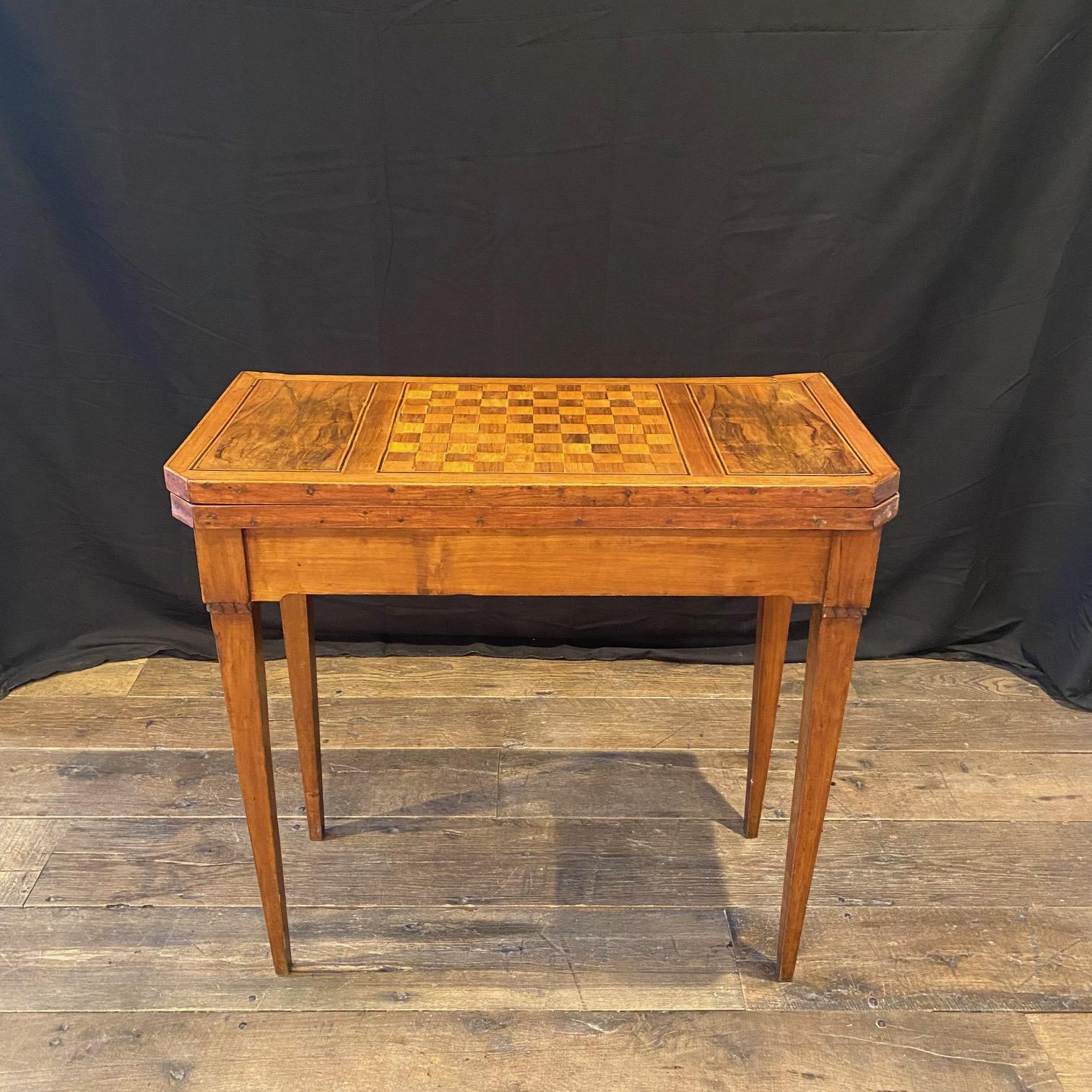 Neoclassical game table from France on tapering square legs in the Louis XVI from the Napoleon III period of the 19th century. The wood is finely inlaid with walnut veneers and rosewood inlays. The table opens to the depth and rotates to the length