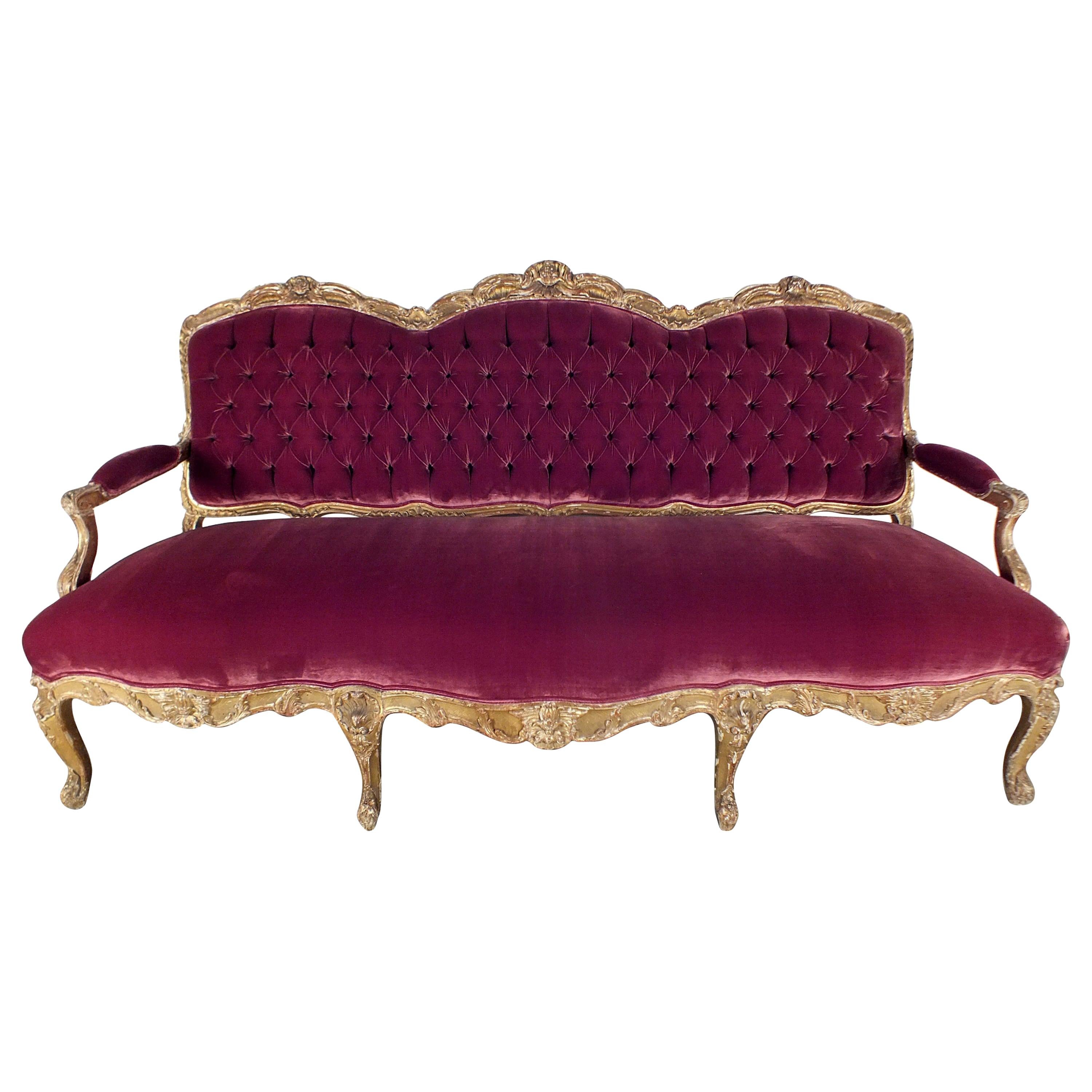 This one-of-a-kind late 18th century Louis XV sofa has been restored by our expert craftsmen and features a solid wood frame with its original gilt finish. The sofa frame is intricate hand carvings of scrolls, leaves, and flowers, seashells, and big