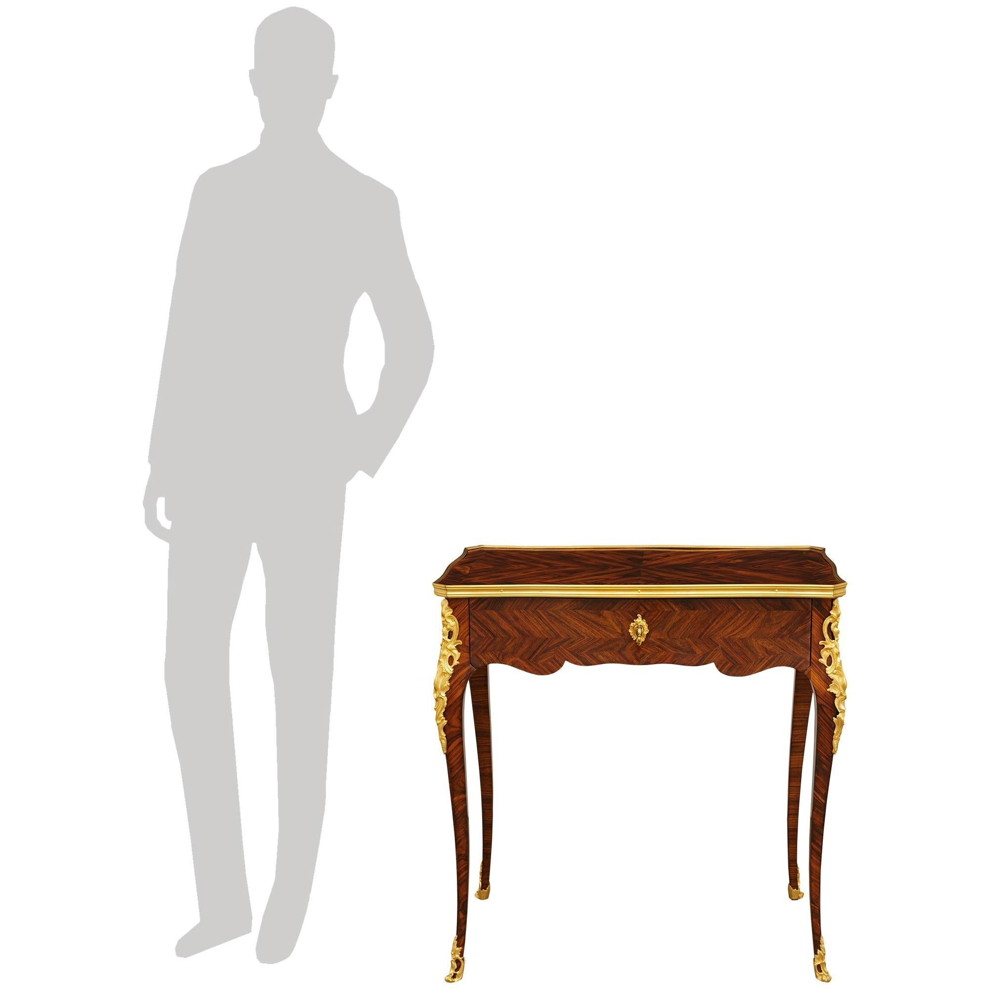 An elegant and most unique French early 19th century Louis XV st. Kingwood and Ormolu desk/side table. This wonderful writing desk/table is raised on slender cabriole legs ending with lovely wrap around and pierced Ormolu sabots. At the top of the