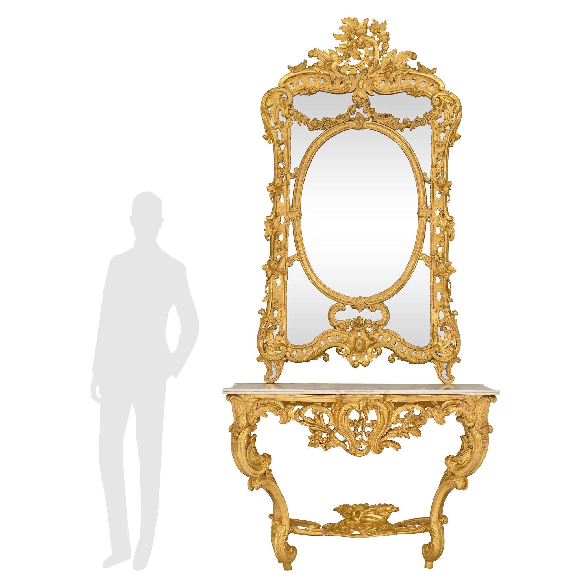 Eine monumentale und beeindruckende französische Konsole aus Goldholz und weißem Carrara-Marmor aus dem frühen 19. Jahrhundert im Stil Louis XV mit passendem Spiegel. Die atemberaubende Wandkonsole wird von außergewöhnlichen Cabriole-Beinen mit