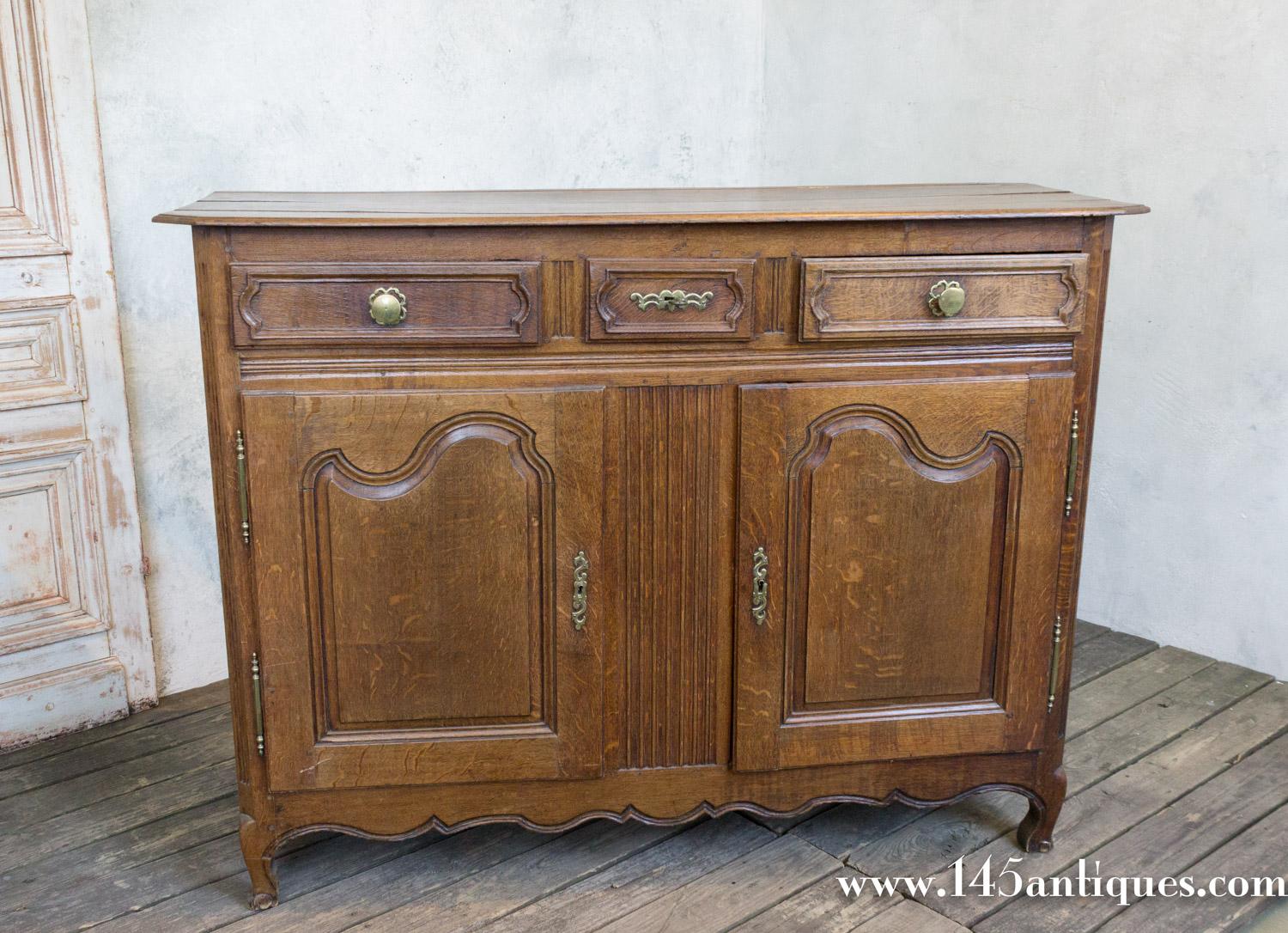 This beautiful French Provincial Louis XV oak buffet still has its original old wax patina and brass hardware and it has two doors and three drawers on the top. Made in the north of France in the early 19th century, it is a very solid and well made