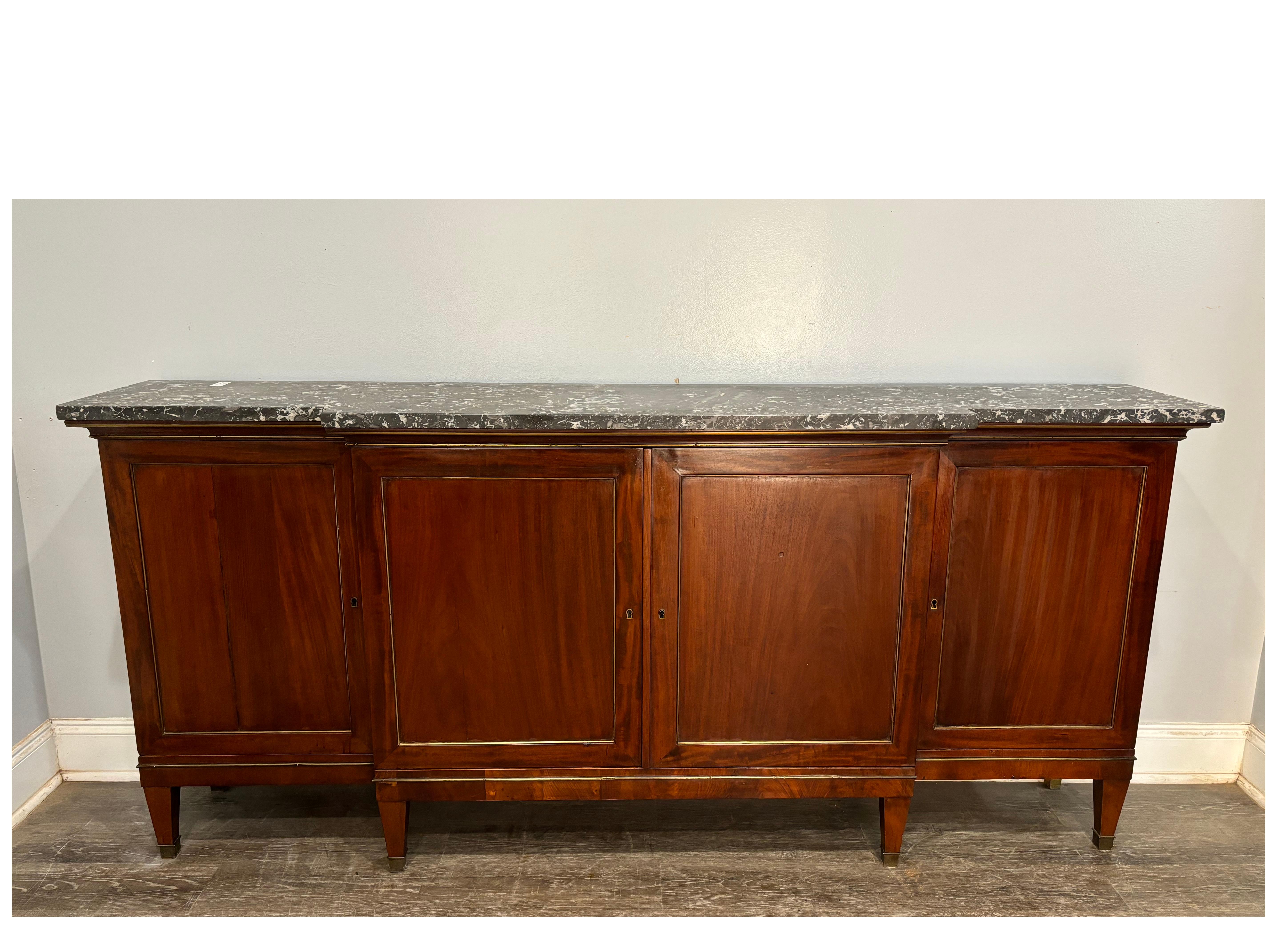 Beautiful Narrow Sideboard made of mahogany with a Sainte-Anne marble top. There are some brass strings around the doors and the sides.