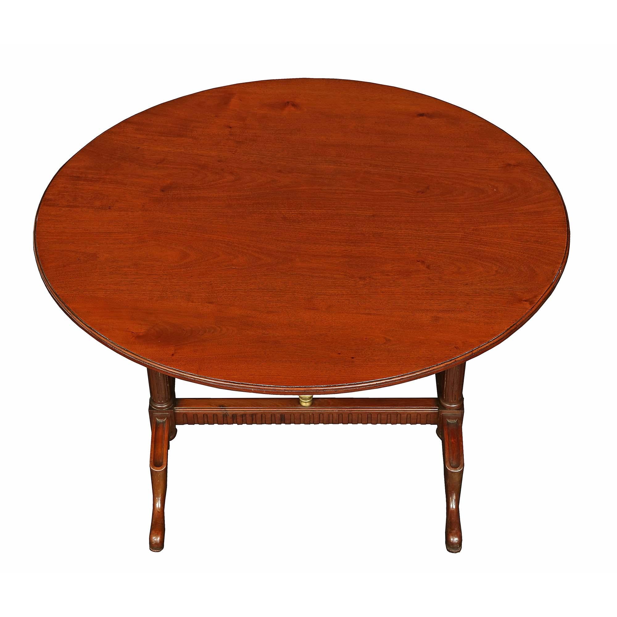 A very attractive French early 19th century Louis XVI st. solid mahogany gateleg table. The table is raised on reeded legs resting on trestle feet centered by an inverted finial and joined by a reeded stretcher. The central curved gate is hinged to