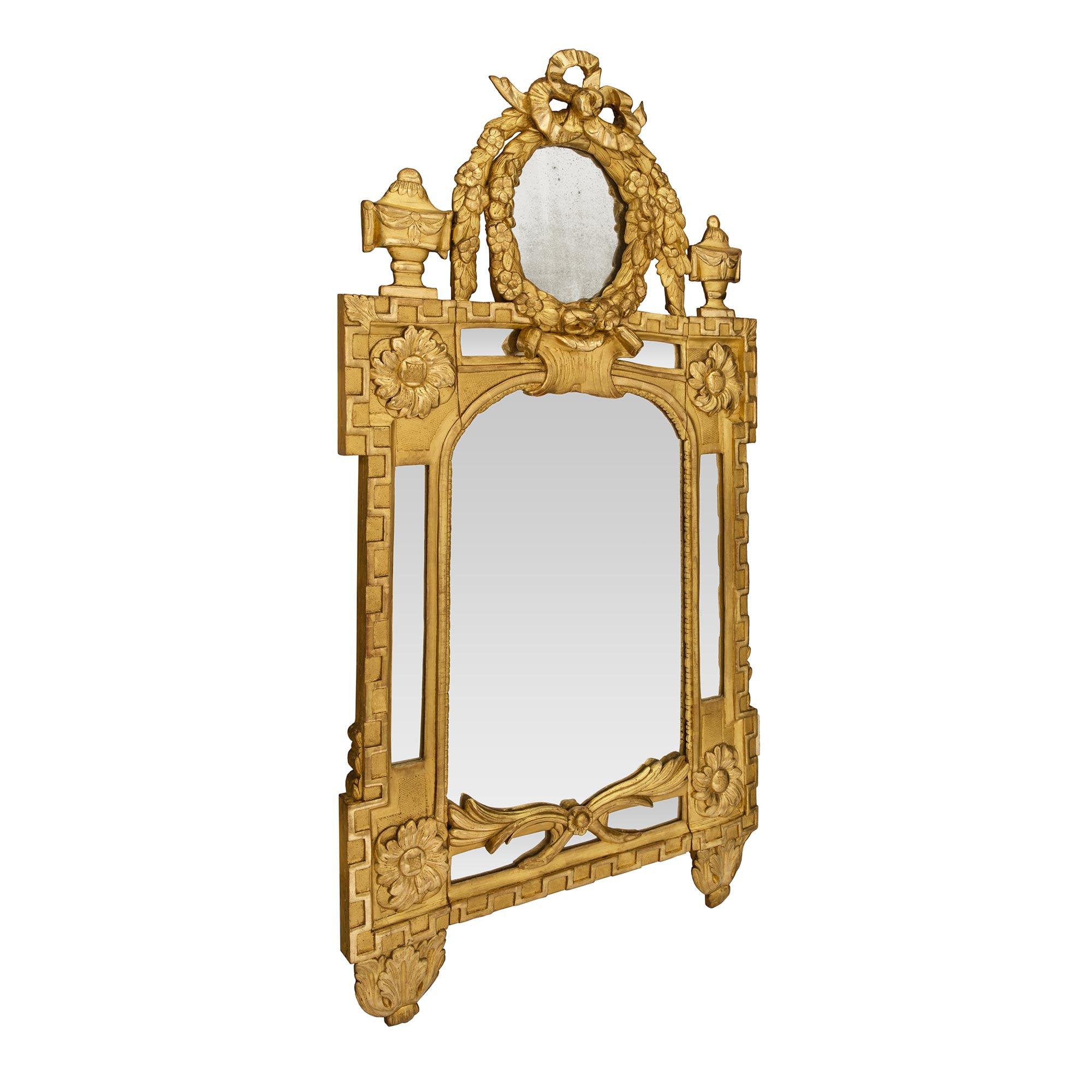 An impressive large scale French early 19th century Louis XVI st. double framed giltwood mirror. The original central mirror plate is framed within a fine mottled border. A beautiful Greek key pattern extends throughout the framed while below are