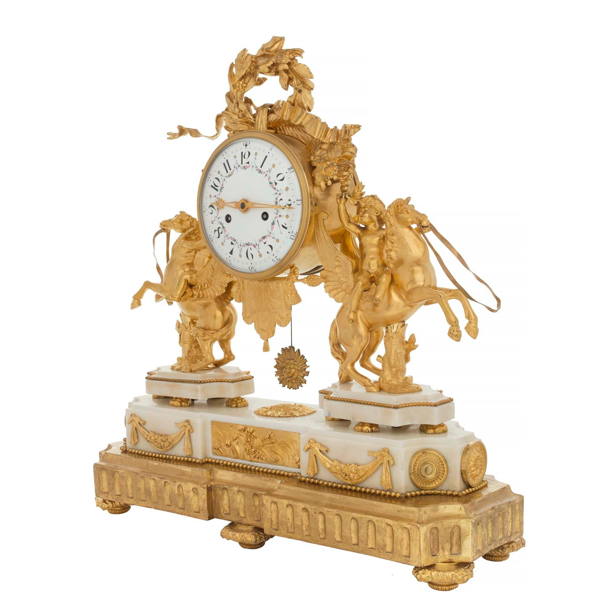 A stunning French early 19th century Louis XVI st. ormolu, white Carrara marble and giltwood clock. The clock is raised by a fine giltwood base which mimics the most decorative shape of the clock. The base of the clock displays topie shaped feet,