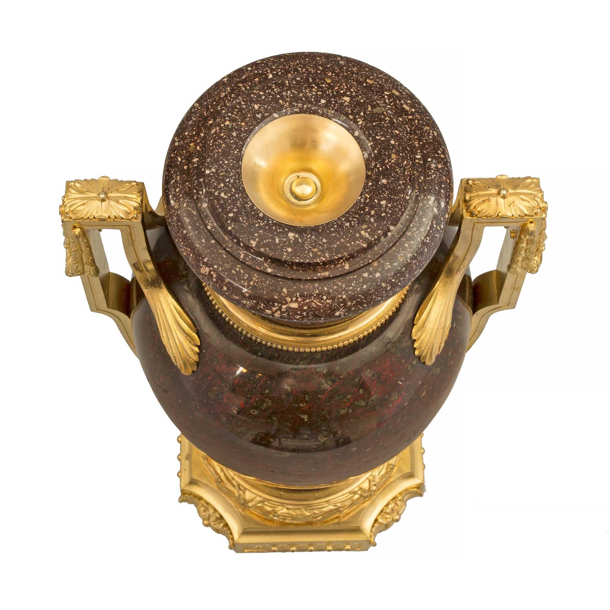Une étonnante et rare paire d'urnes en porcelaine et bronze doré de style Louis XVI, datant du début du XIXe siècle. Les urnes sont surmontées d'une base carrée aux angles concaves, avec des rosettes de feuillage richement ciselées et centrées sur