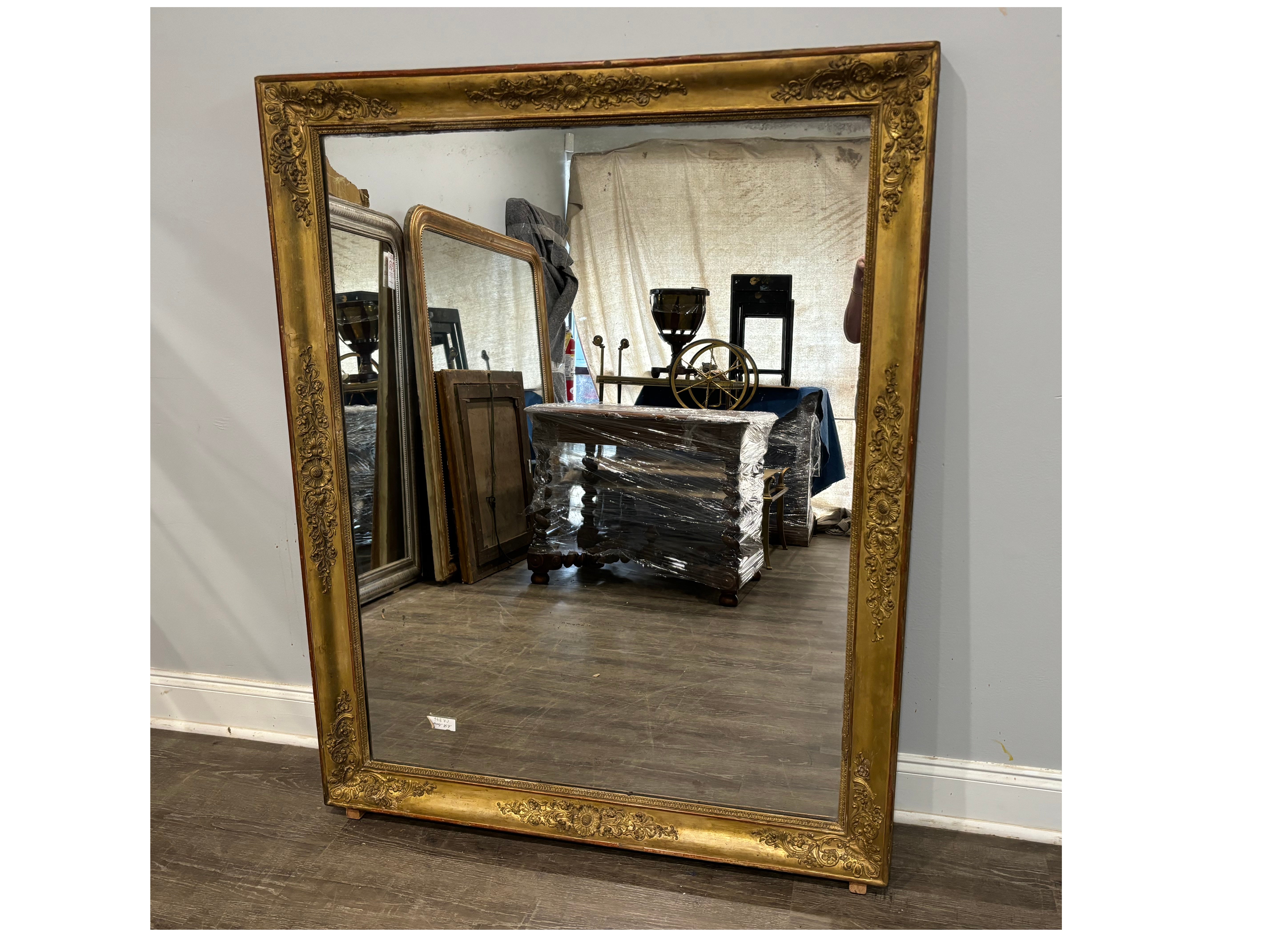 Questo specchio è realizzato in legno ricoperto di gesso con foglie d'oro sulla parte superiore. Ha uno specchio al mercurio con qualche segno dell'età.