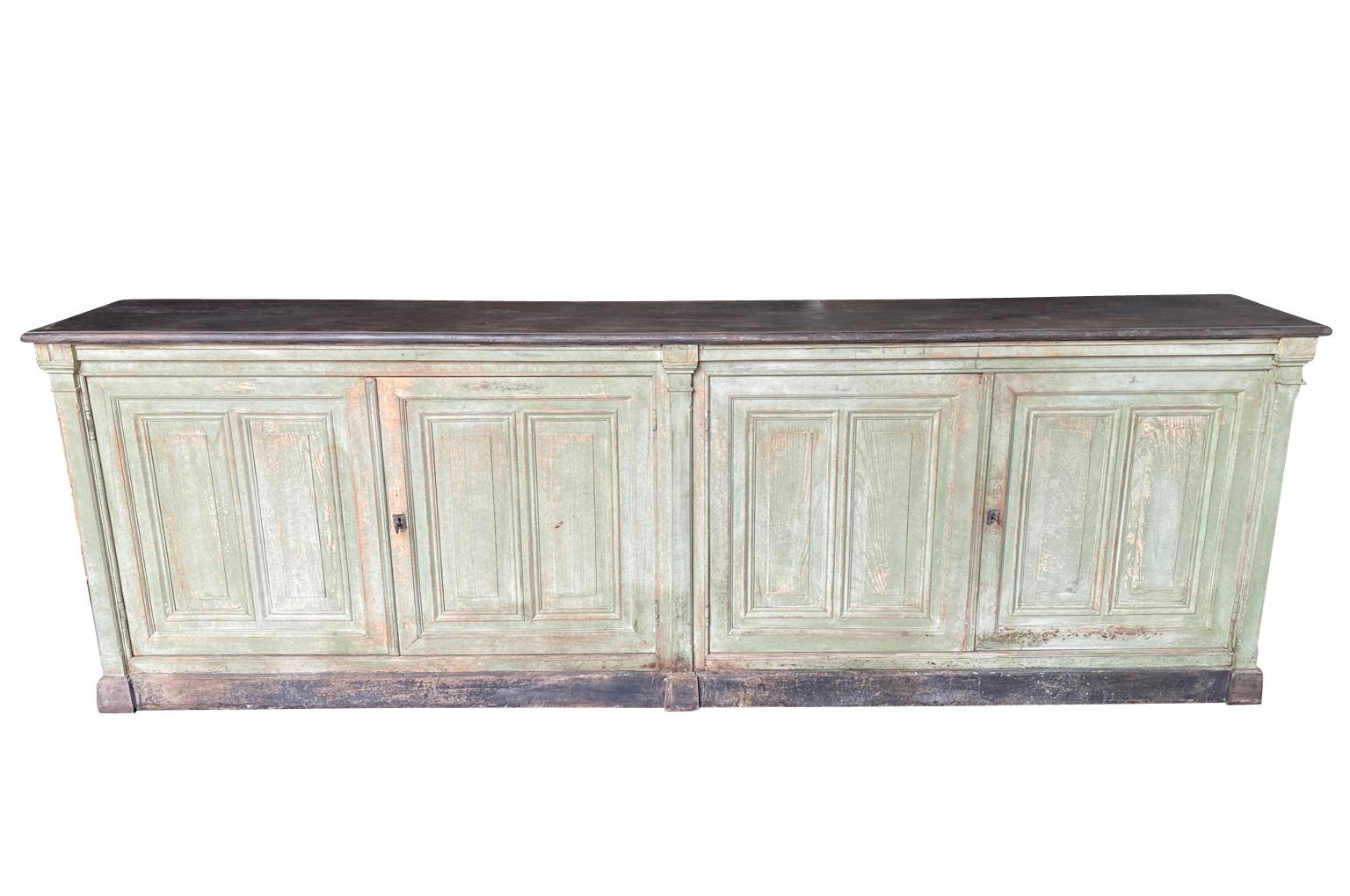 A wonderful early 19th century Enfilade - Buffet from the Provence region of France.  Soundly constructed from painted oak with 2 double doors, interior shelving and raised on a plinth base.  Super patina and finish.  Great storage piece with narrow