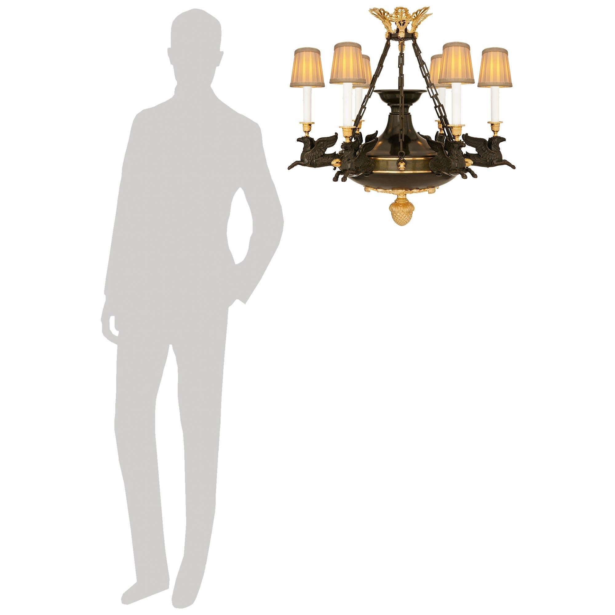 Lampadario francese di alta qualità e molto decorativo del periodo della Restaurazione, circa 1830, in ormolu e bronzo patinato. Questo splendido lampadario a sei bracci e sei luci è centrato in basso da un imponente terminale a ghianda riccamente