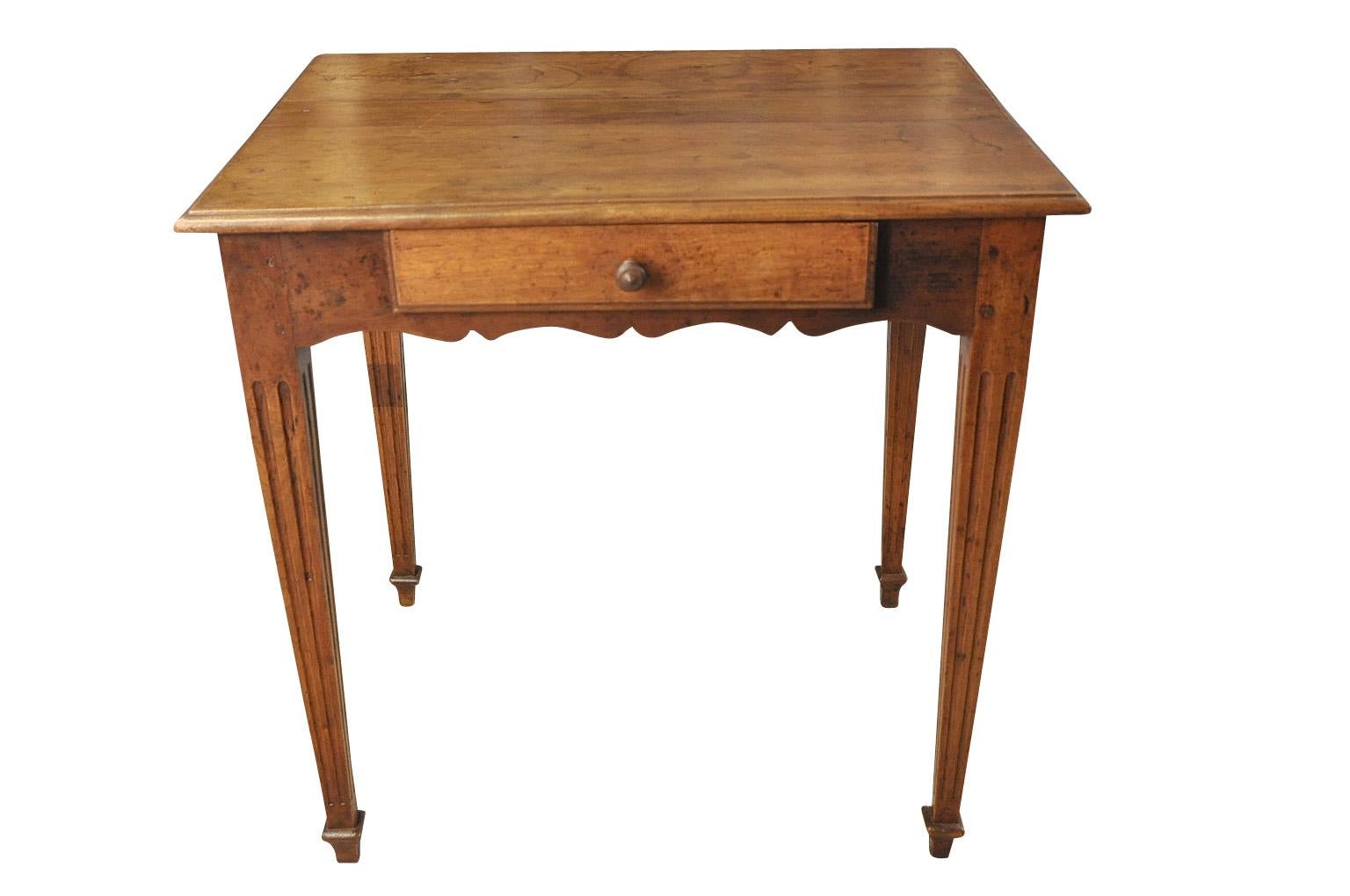 A very charming early 19th century side table from the South of France. Wonderfully constructed from walnut with fluted tapered legs, a sculpted apron and a single drawer.