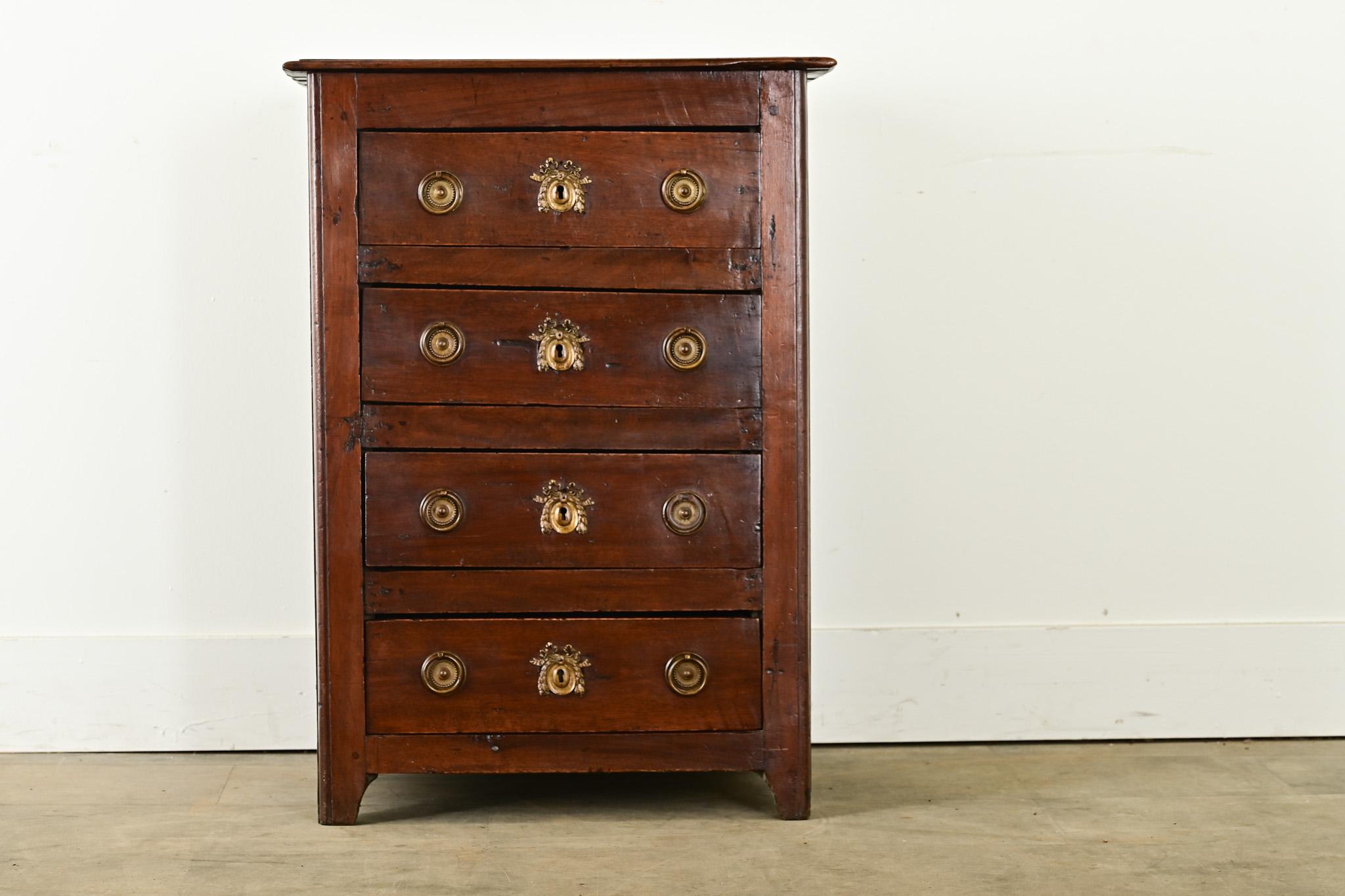 Una deliziosa petite commode proveniente dalla Francia, inizio del XIX secolo. Realizzato in noce con una struttura semplice, le venature del legno sono ricche di colori e motivi, il piano d'appoggio semplice si trova sopra una cassa con quattro