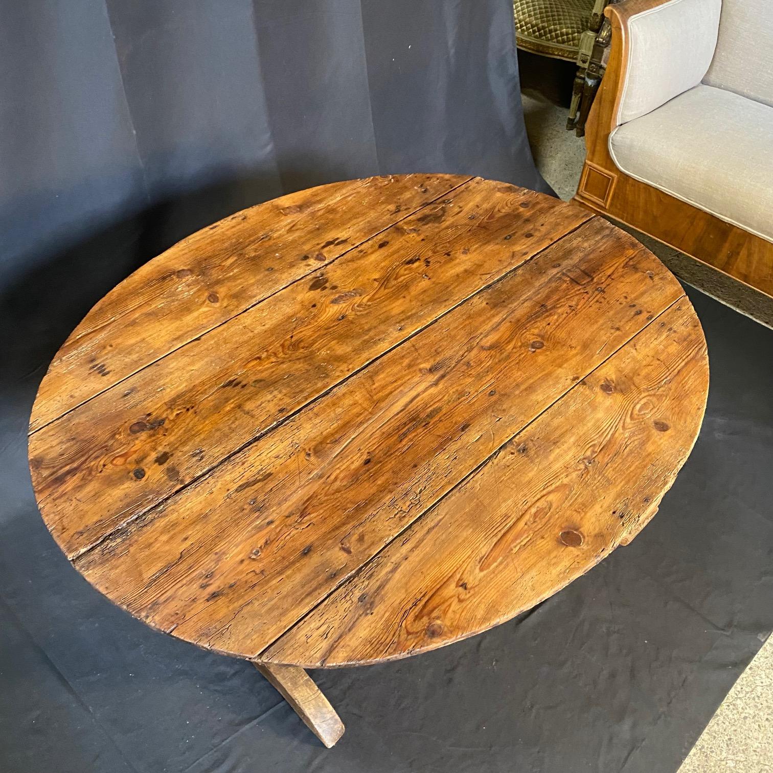Charmante table de vendange en noyer, vers la fin des années 1800. Le plateau ovale est entouré d'un bord en bois courbé et repose sur une base à tréteaux avec un mécanisme de harpe triangulaire. Pieds arrondis sculptés. Tilt-top entièrement