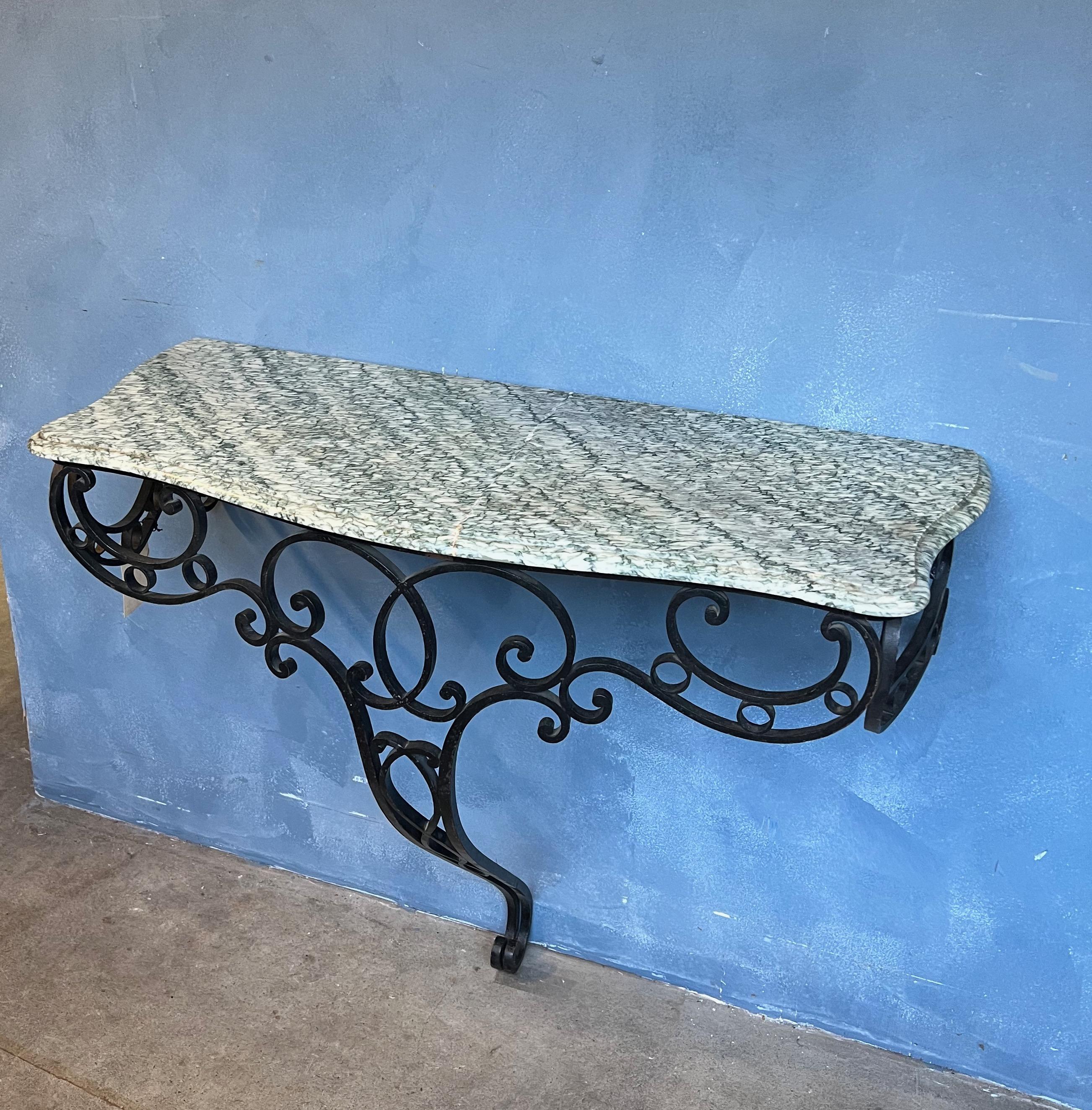 A stunning console from the early 20th century, this French wrought iron piece features an intricately detailed base and ornate rococo styling. This wall-mountable console will add a touch of old world charm to any room it graces, whether it be your