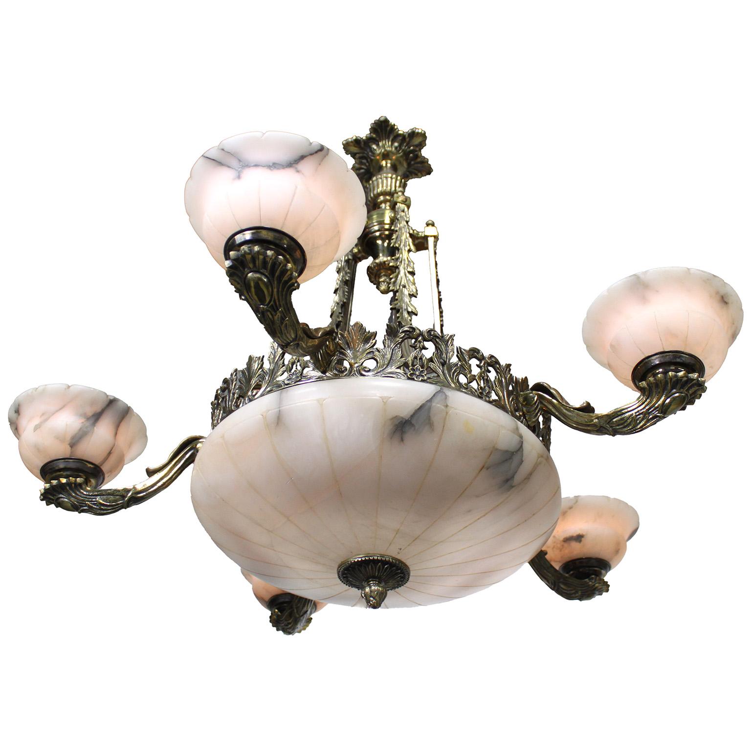 Lampadario a cinque luci in bronzo e alabastro venato intagliato francese dei primi del Novecento. La cornice circolare traforata a fiori è sospesa da quattro steli con un baldacchino a raggiera, cinque luci a forma di cornucopia a volute, tutte